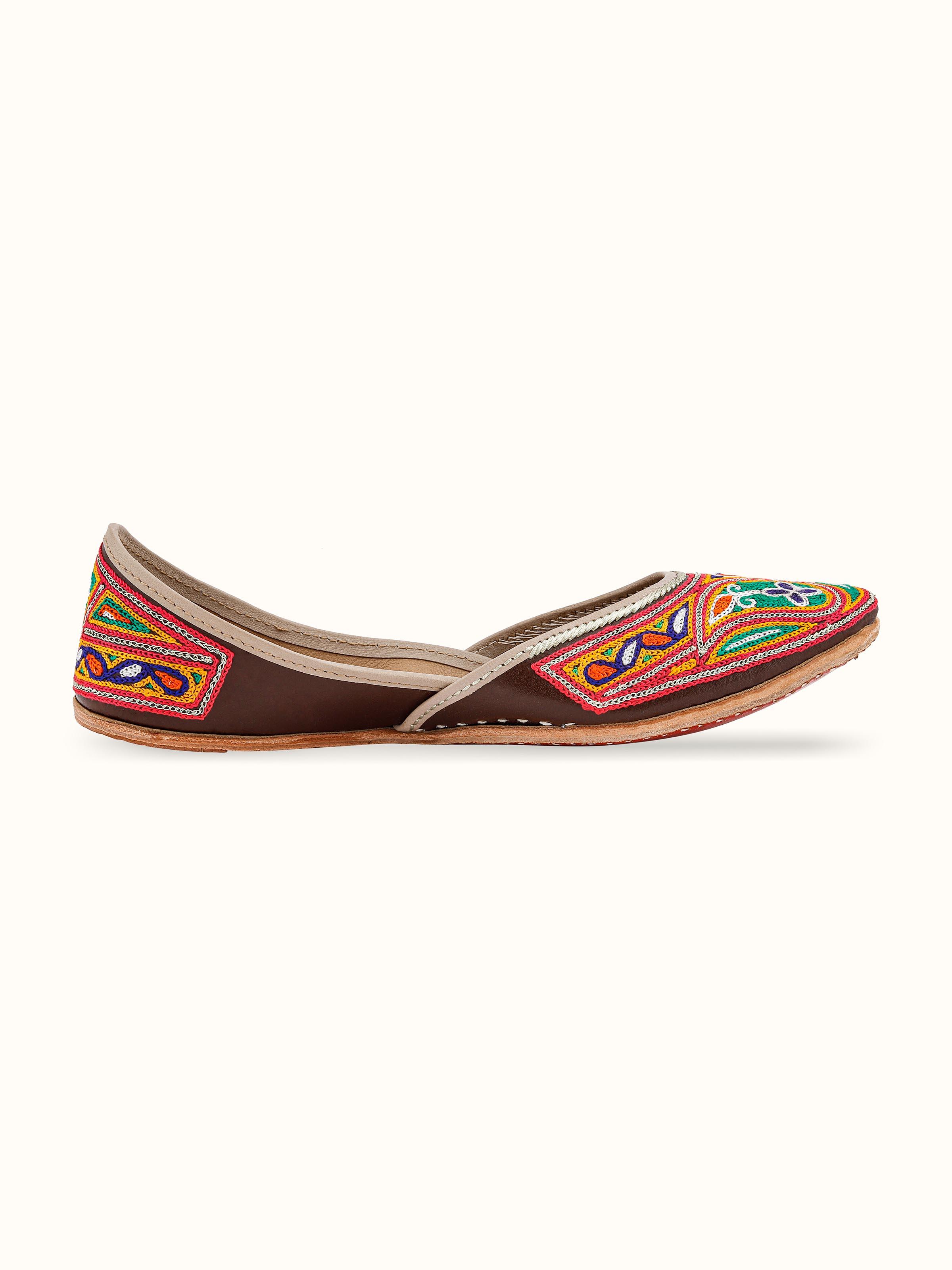 Angle view of Tan leather haryana embroidered juttis showing design intricacies