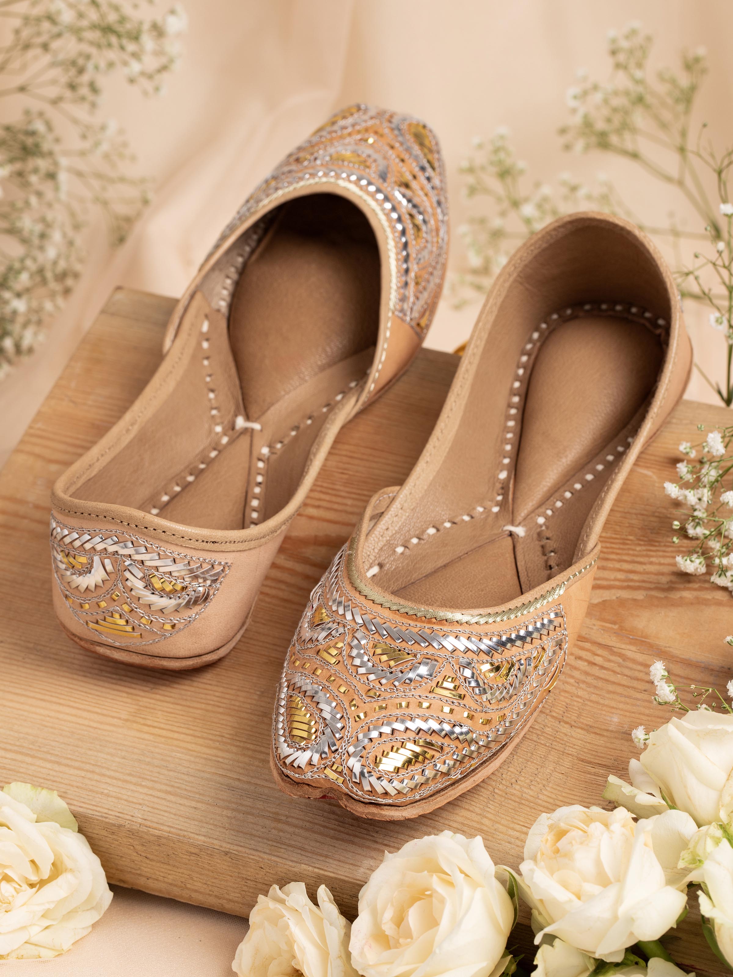 Side view of Ecru Leather Haryana Juttis highlighting curved toe and handcrafted details.