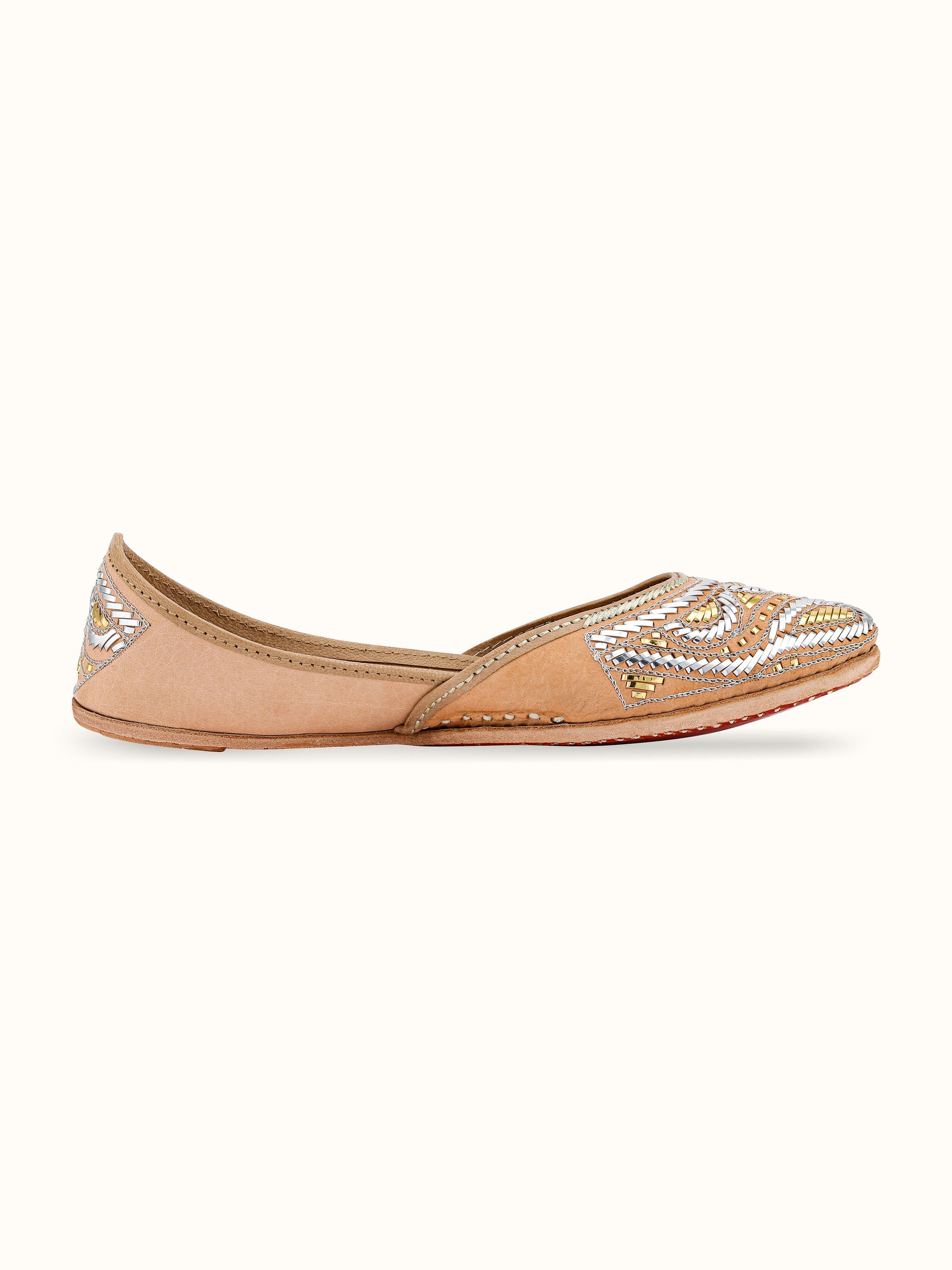 Angled view of Ecru Leather Haryana Juttis showcasing overall shape and design.