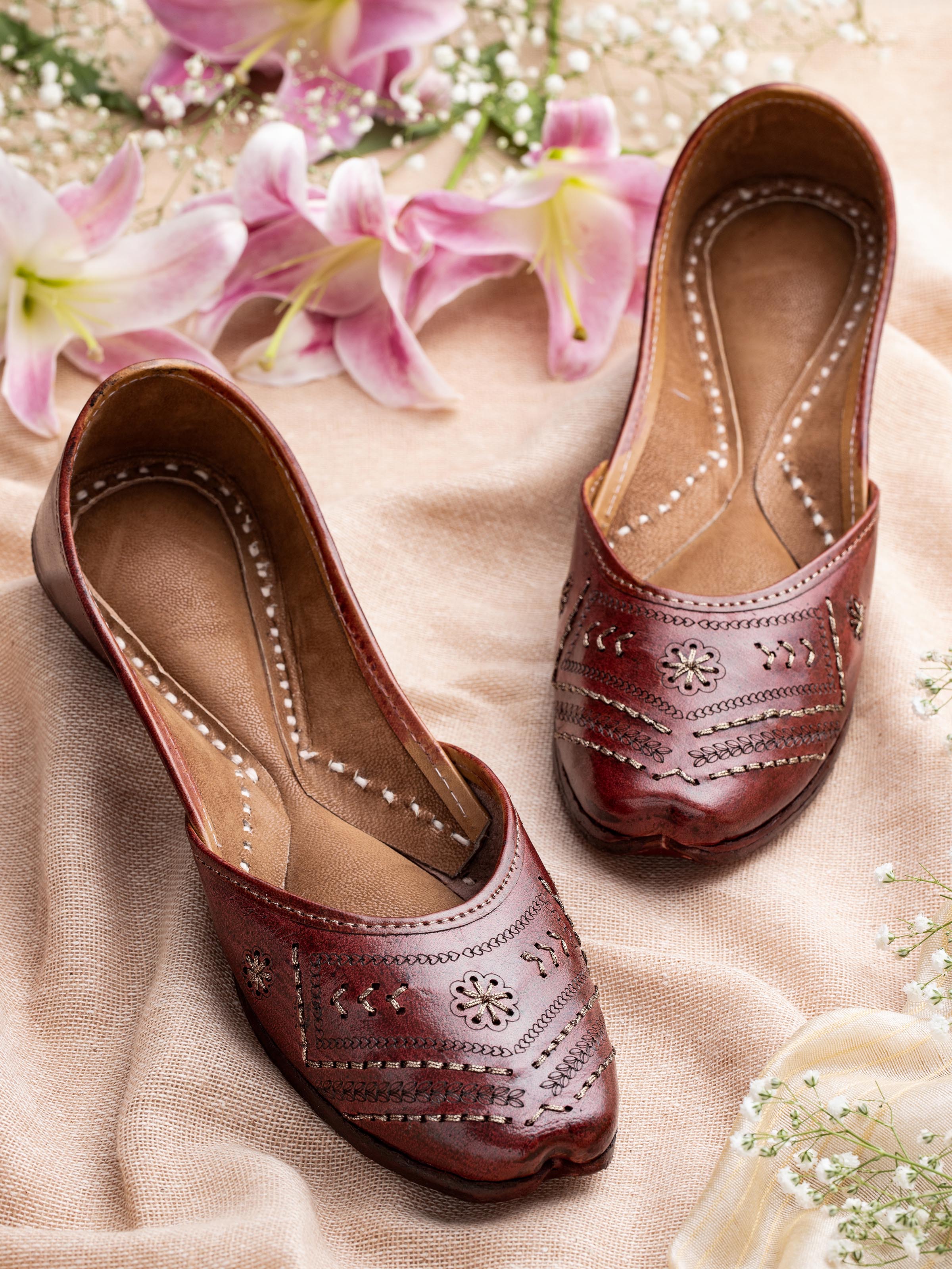 Side view of tan leather Haryana juttis highlighting the profile and stitching details