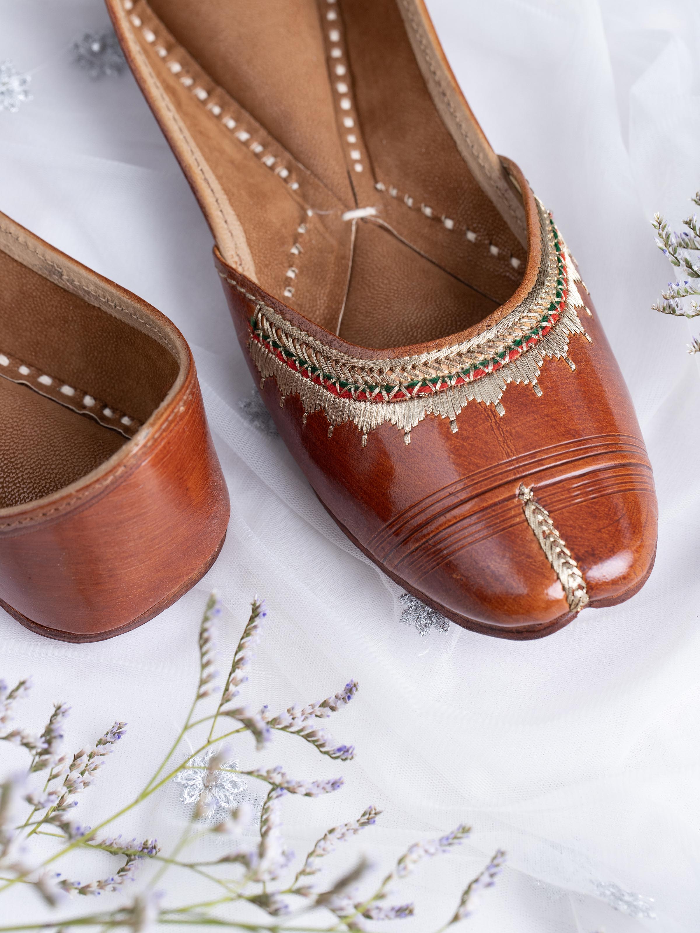 Close-up of tan leather haryana juttis emphasizing fine leather details