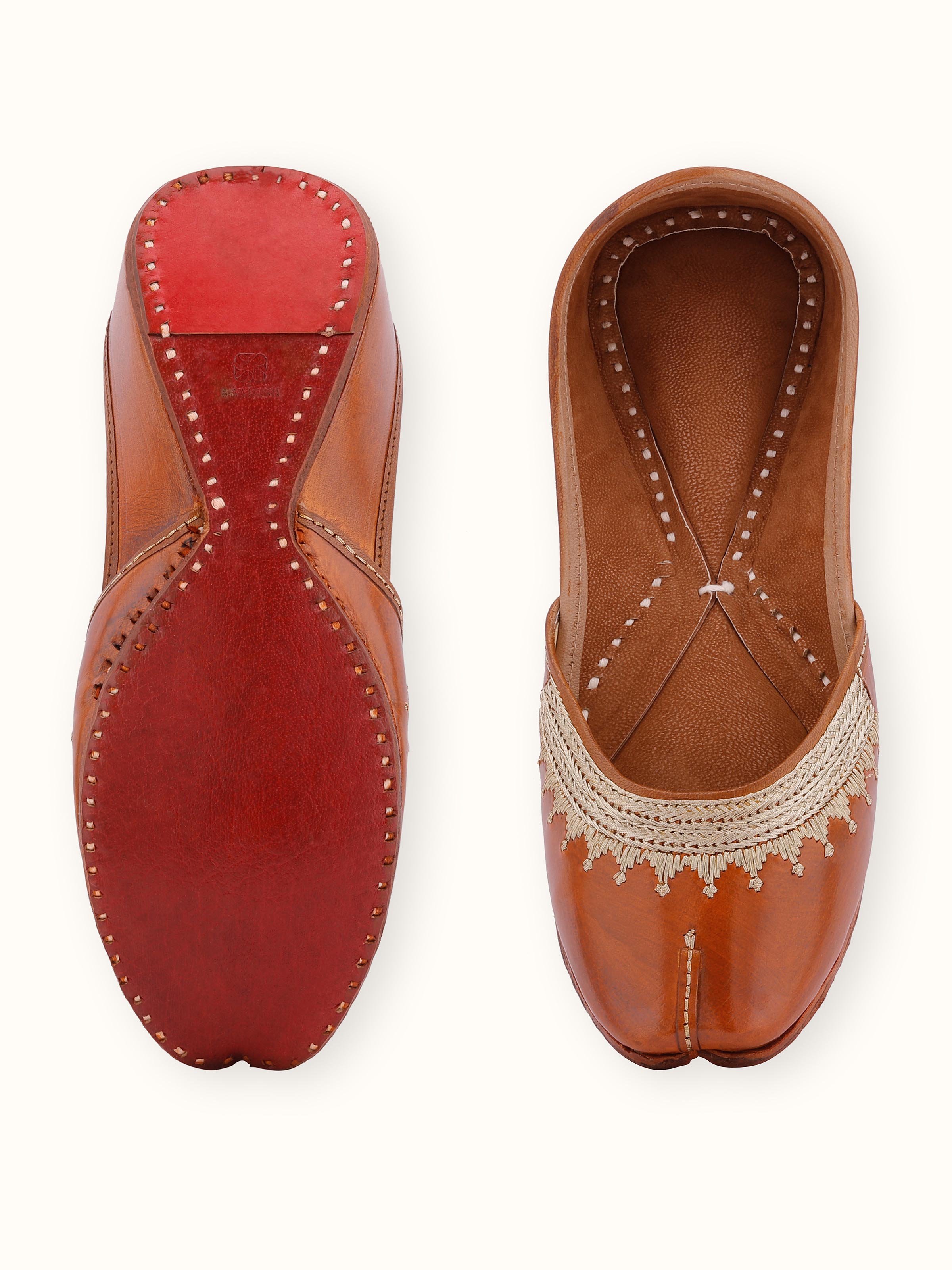 Close-up view of Mustard leather haryana juttis emphasizing embroidery
