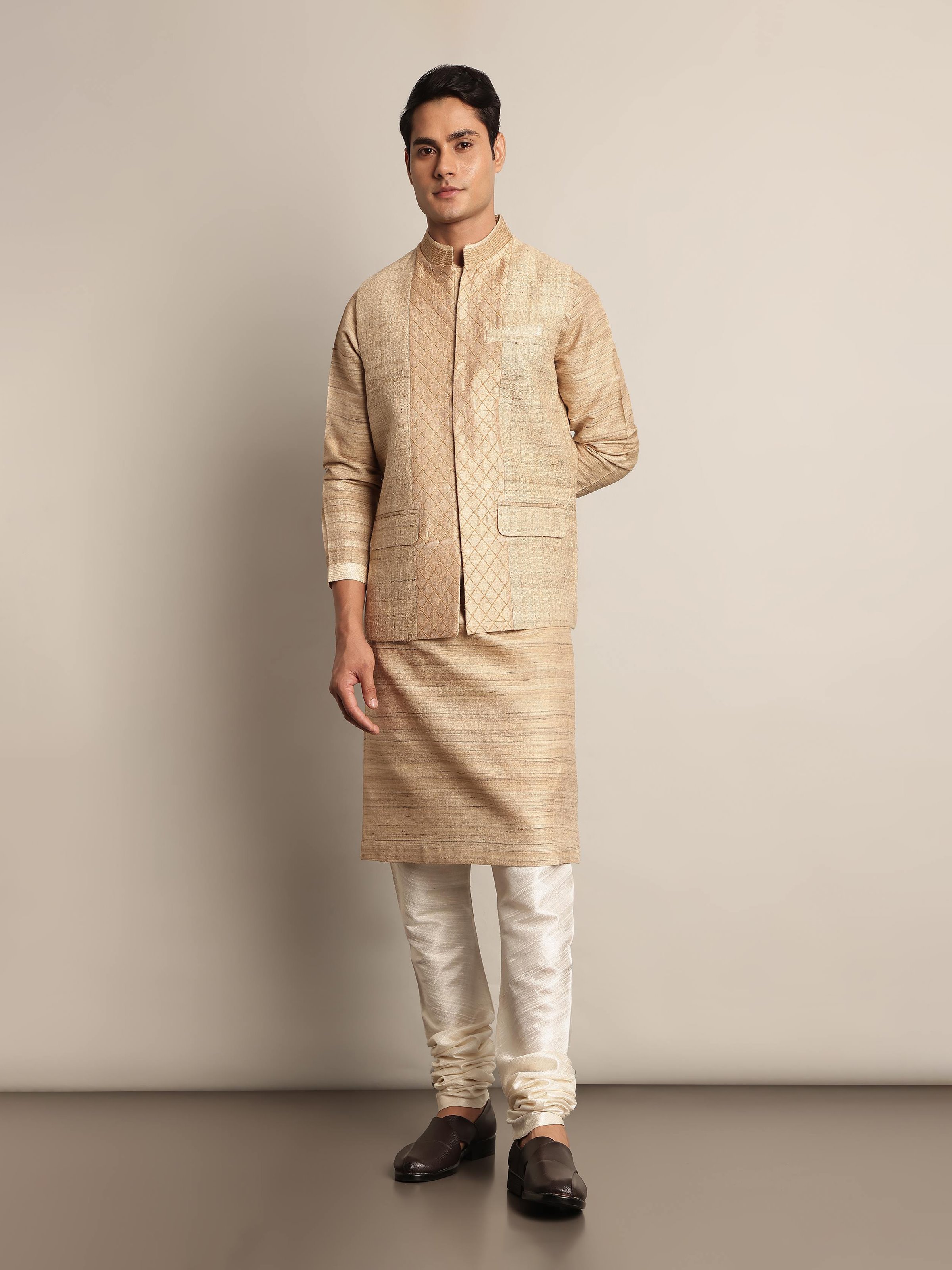 Lifestyle view of beige sleeveless jacket styled with ethnic attire in a heritage setting.