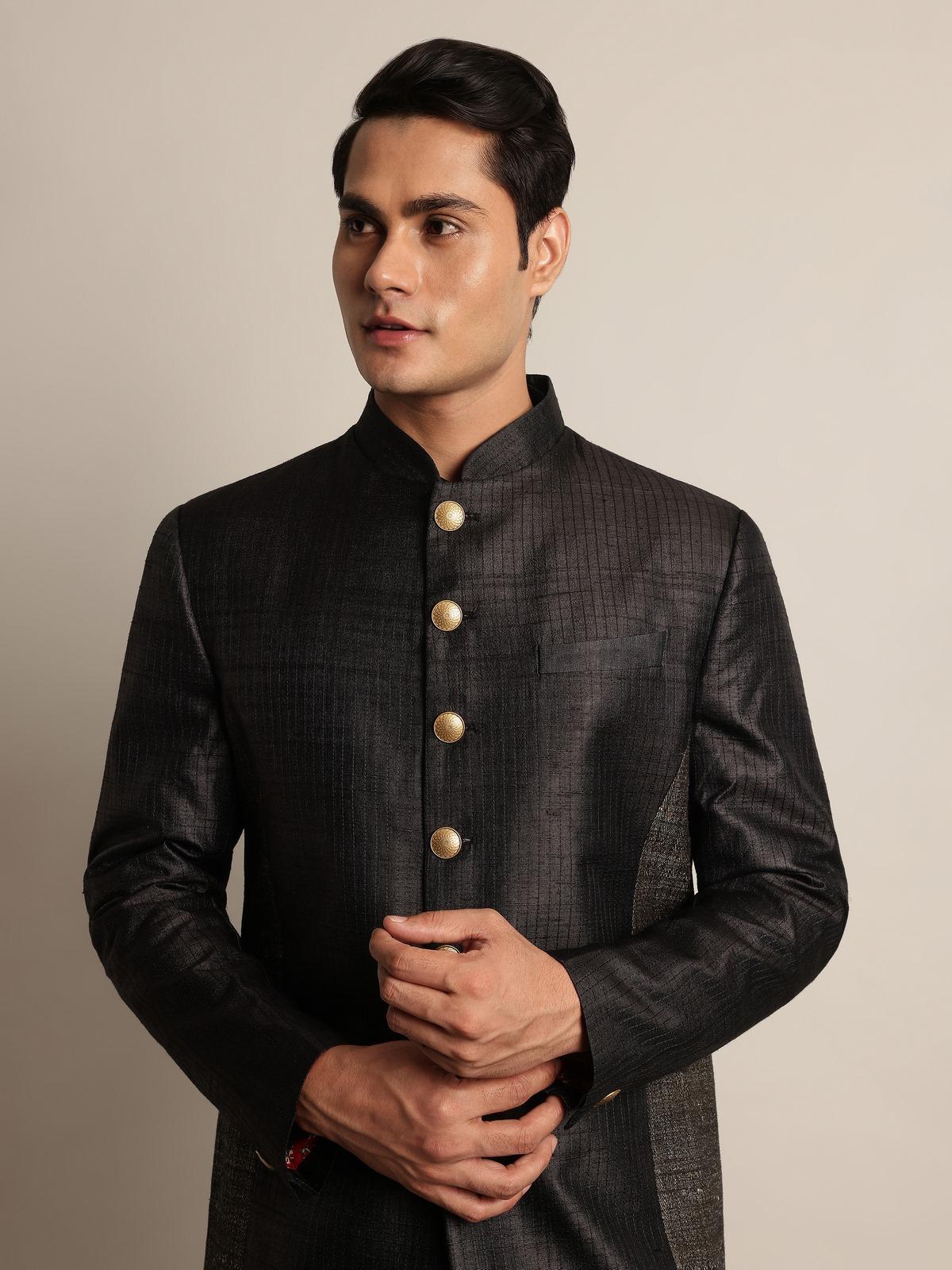 Detailed shot of sherwani sleeve and collar embroidery on black tussar silk fabric.
