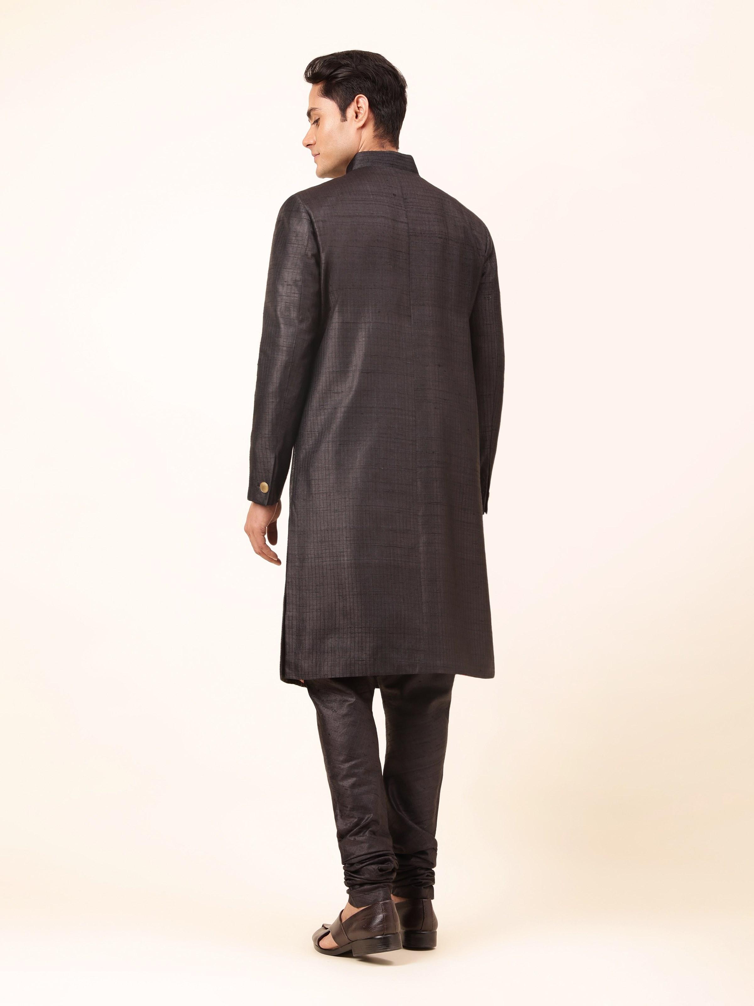 Back view of black tussar silk sherwani on mannequin, showcasing embroidered patterns along the back and smooth silk finish.
