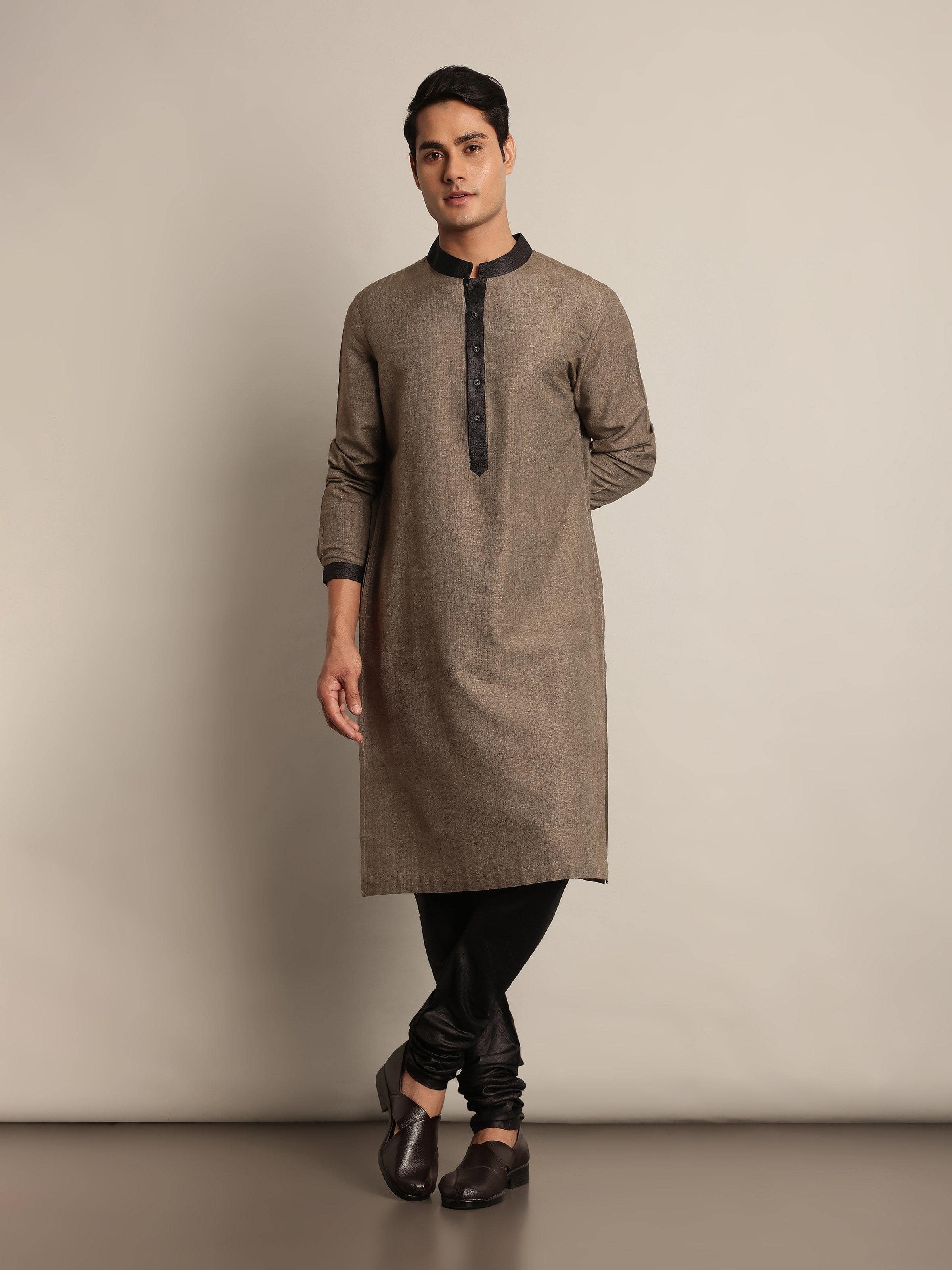 Lifestyle view of light brown Tussar silk kurta styled with white pants.