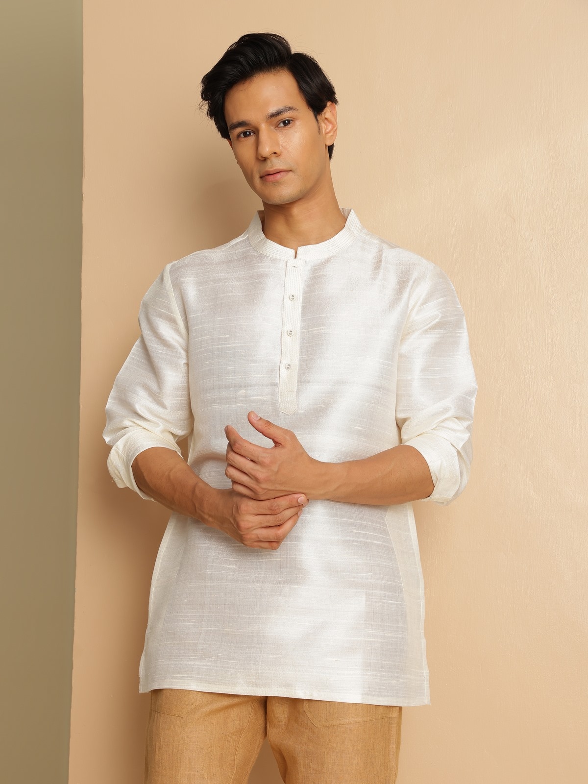 Angled lifestyle view of off-white silk kurta emphasizing fabric texture and drape