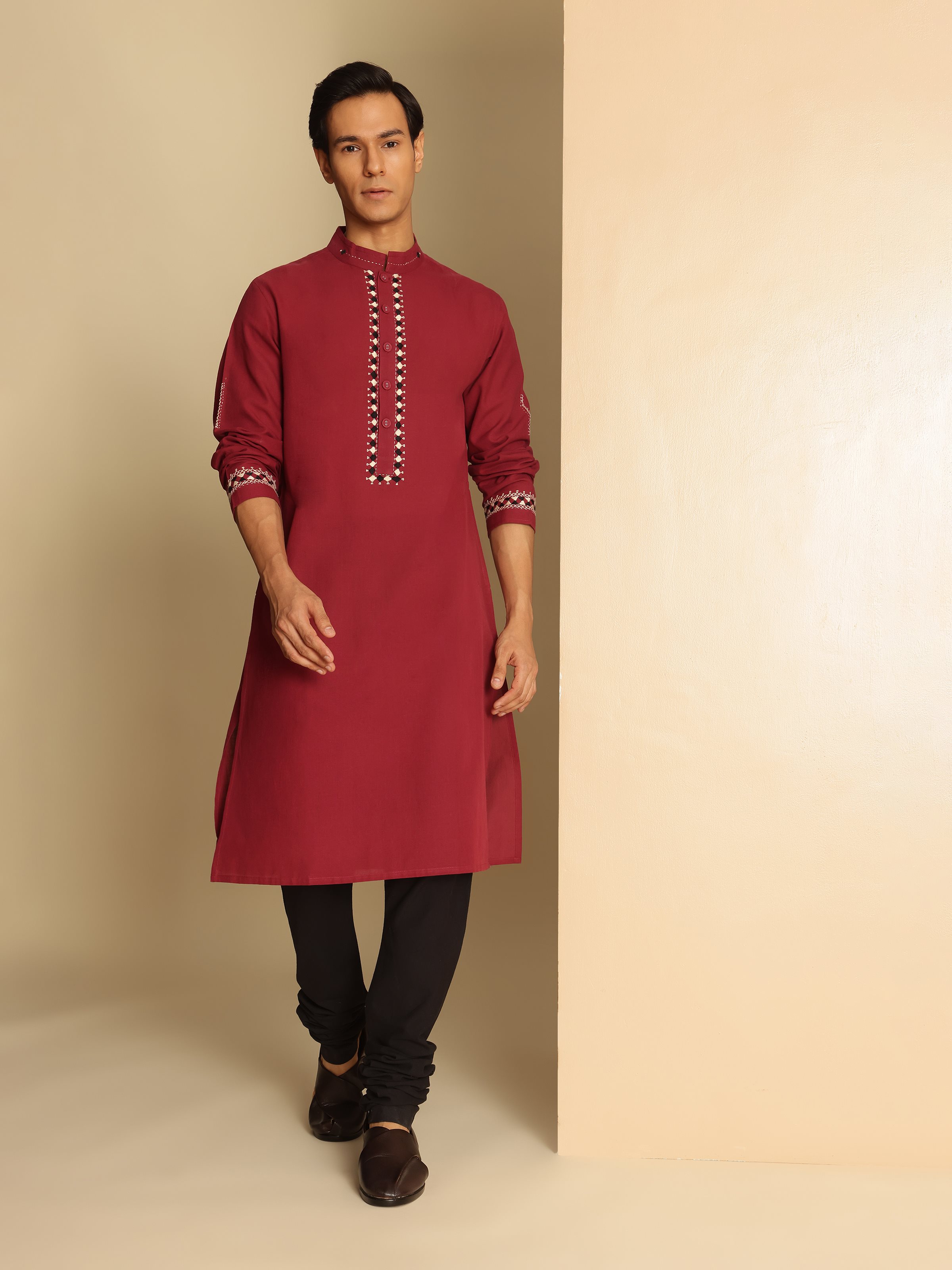Lifestyle view of maroon embroidered kurta styled with white salwaar for festive dressing