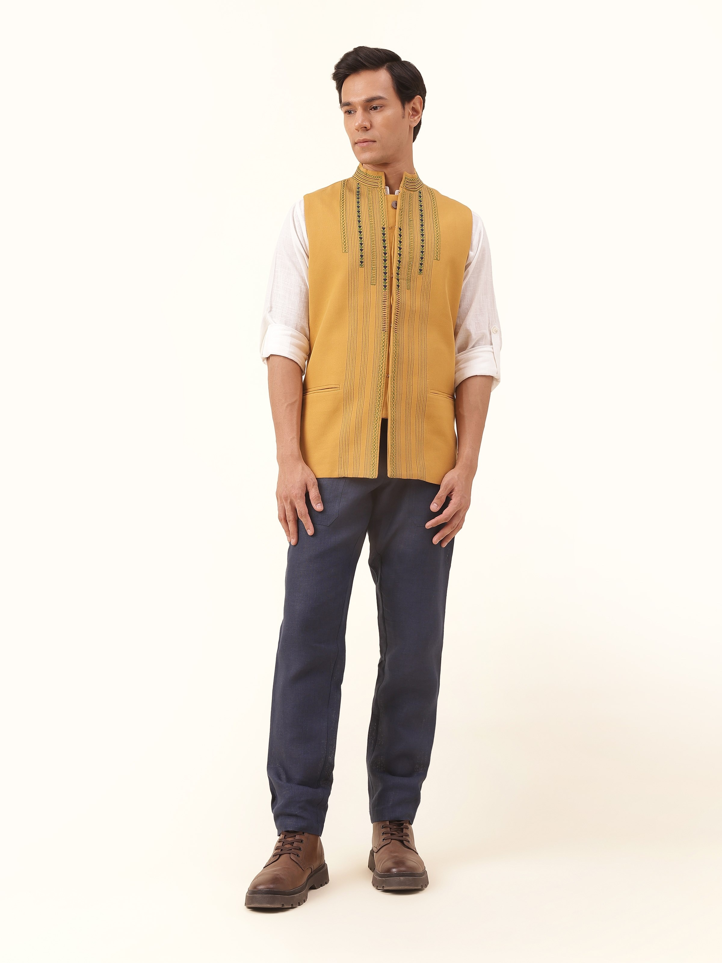 Mustard Cotton Soof Embroidered Sleeveless Jacket worn by model in front-facing pose, showcasing intricate embroidery and structured fit.