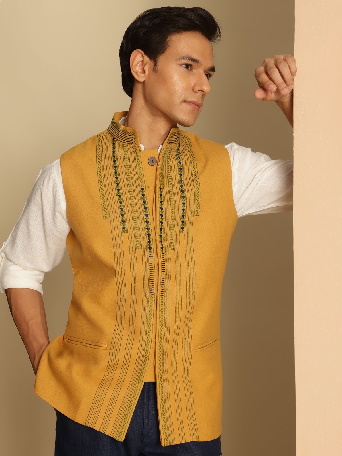 Angled pose of model in Mustard Soof Embroidered Jacket emphasizing hand-stitched detailing and collar design.