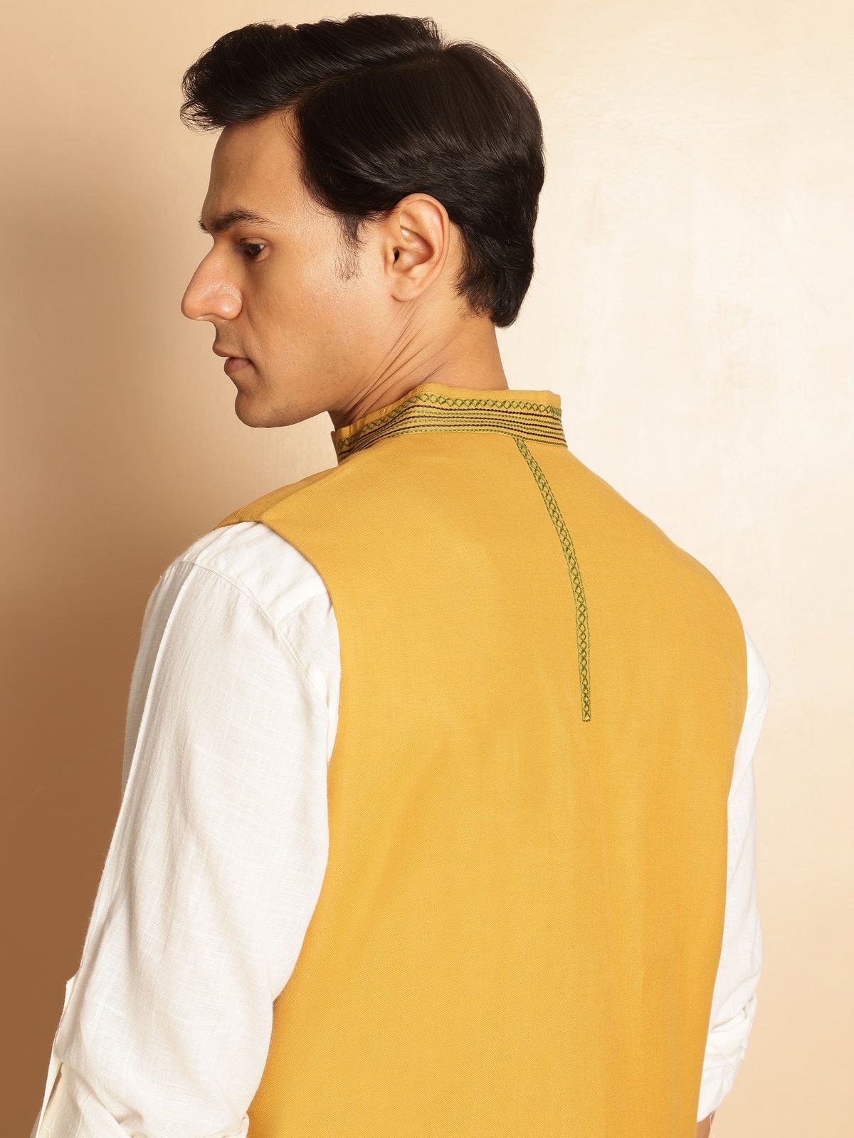 Close-up side view of Mustard Cotton Jacket showing embroidery pattern and sleeveless armhole finish.