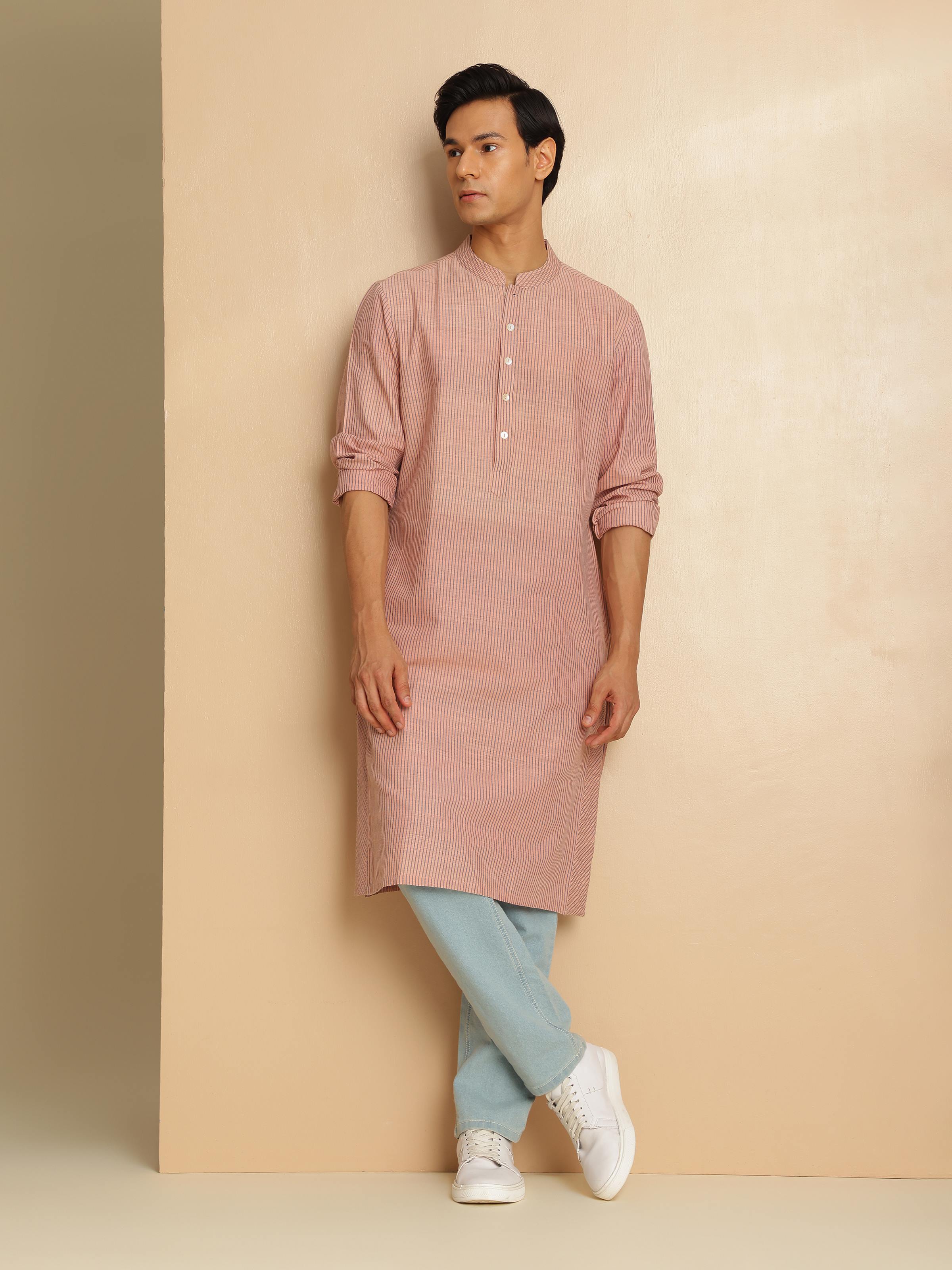 Detailed view of model wearing light pink cotton kurta styled with white pants, showcasing relaxed fit and soft fabric.