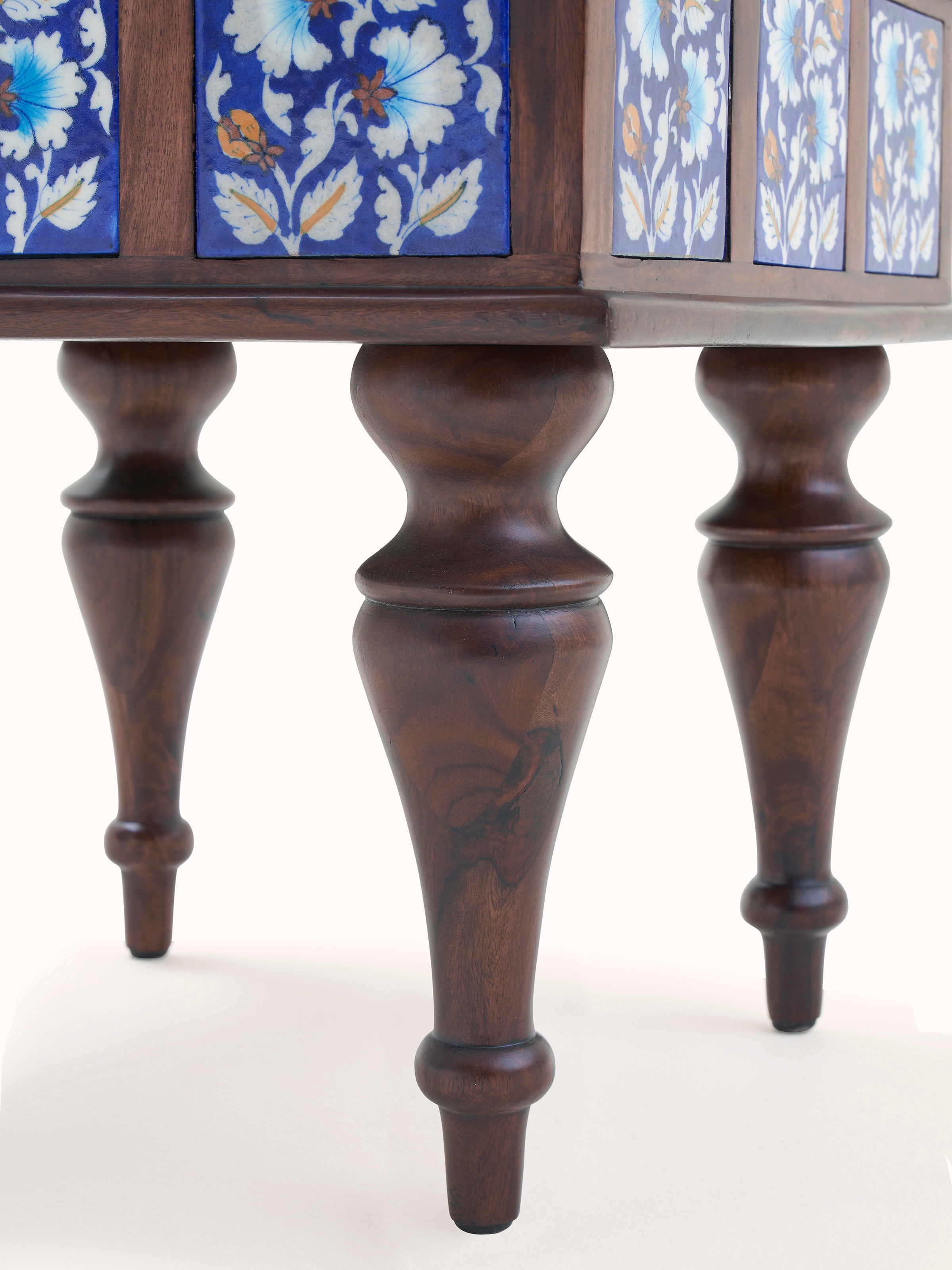 Close-up of Sheesham wood blue pottery upholstered stool, showcasing the fine upholstery and wooden details