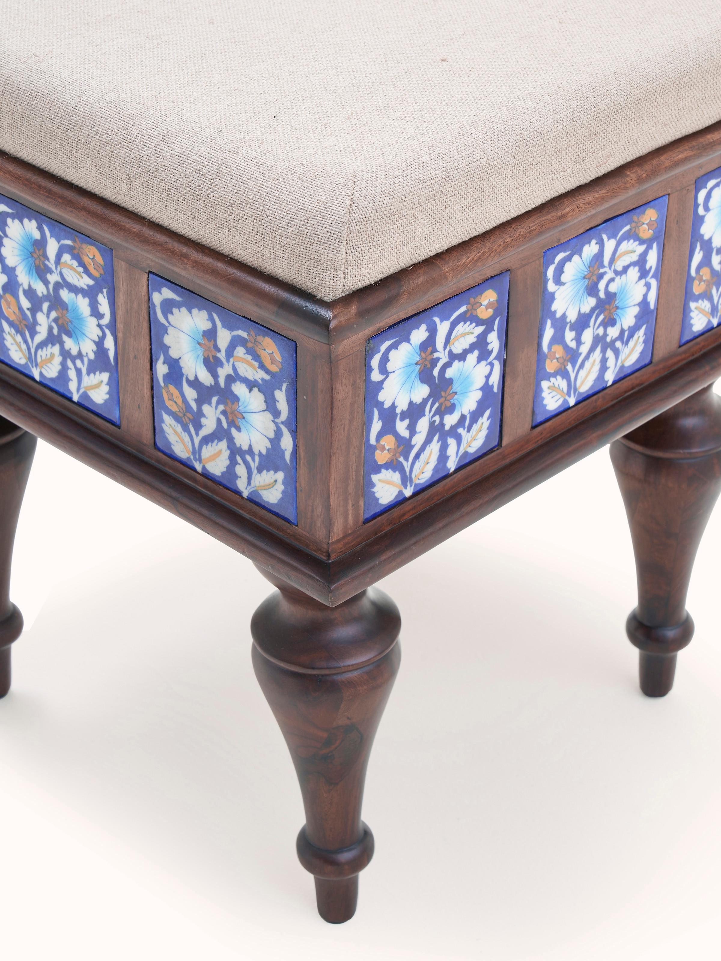 Detailed shot of Sheesham wood blue pottery upholstered stool, highlighting the craftsmanship and design elements