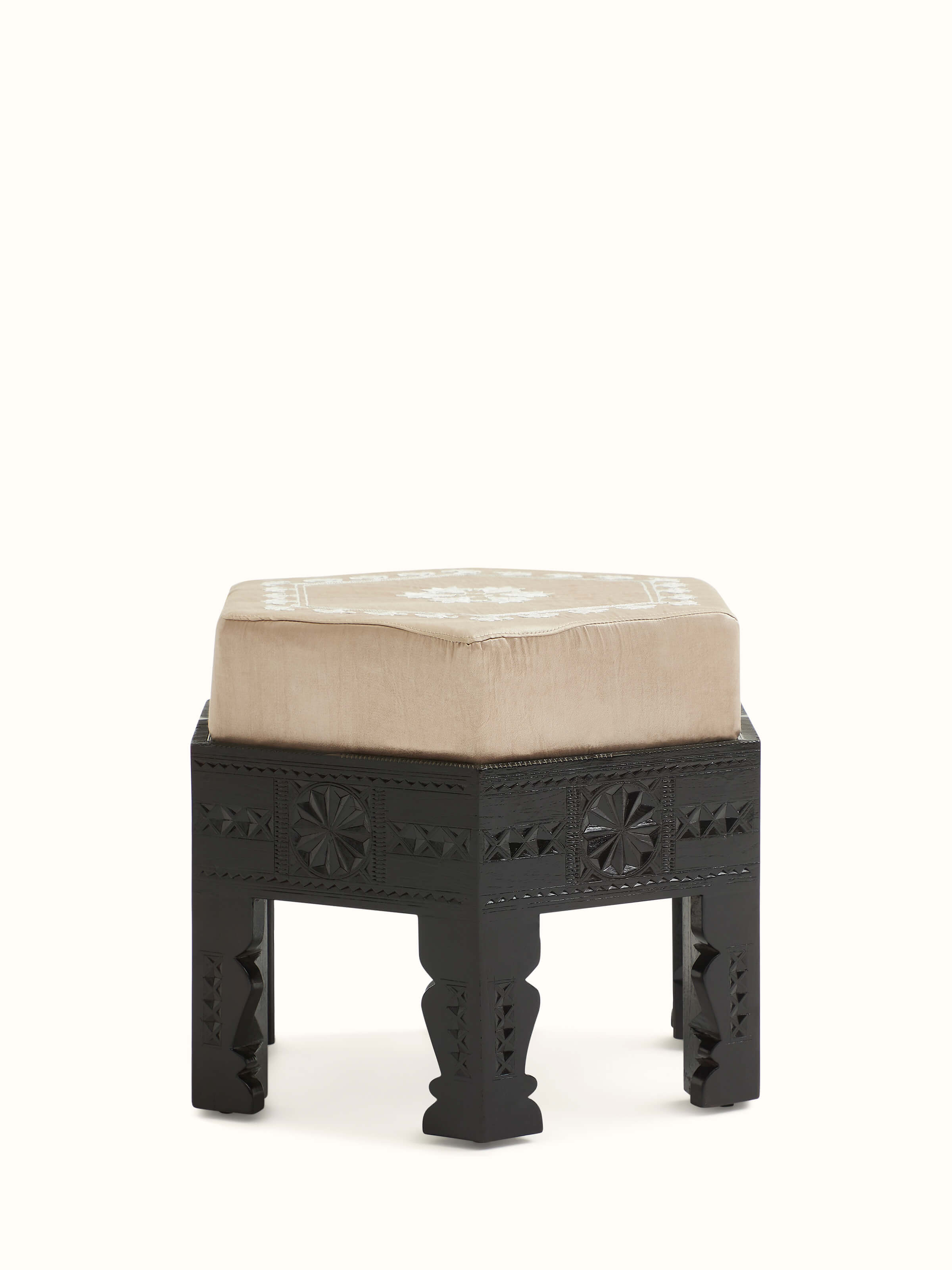 Front view of upholstered carved teak wood round pouffe showcasing intricate design