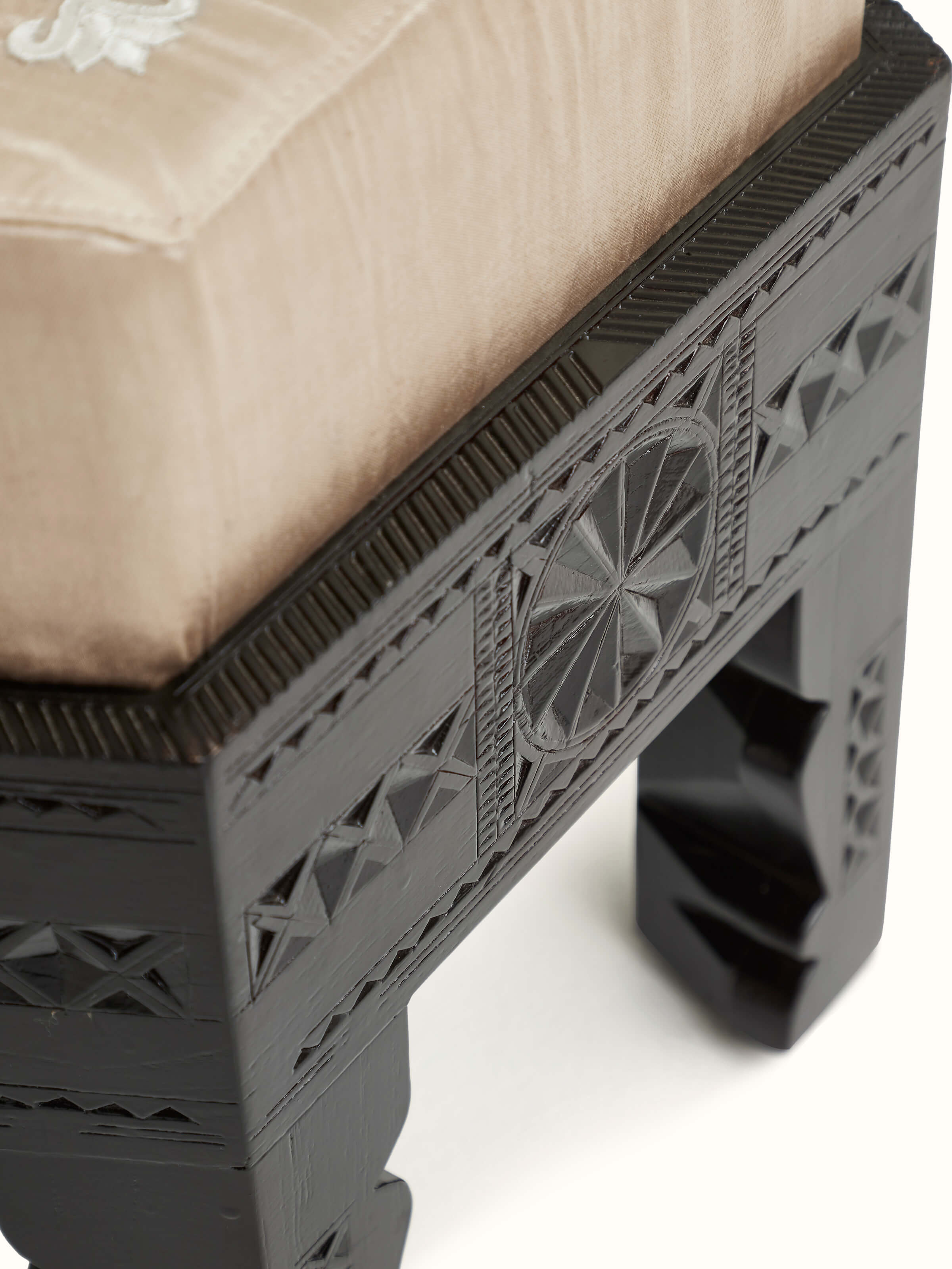 Top view of upholstered carved teak wood round pouffe showcasing the fabric and wood details