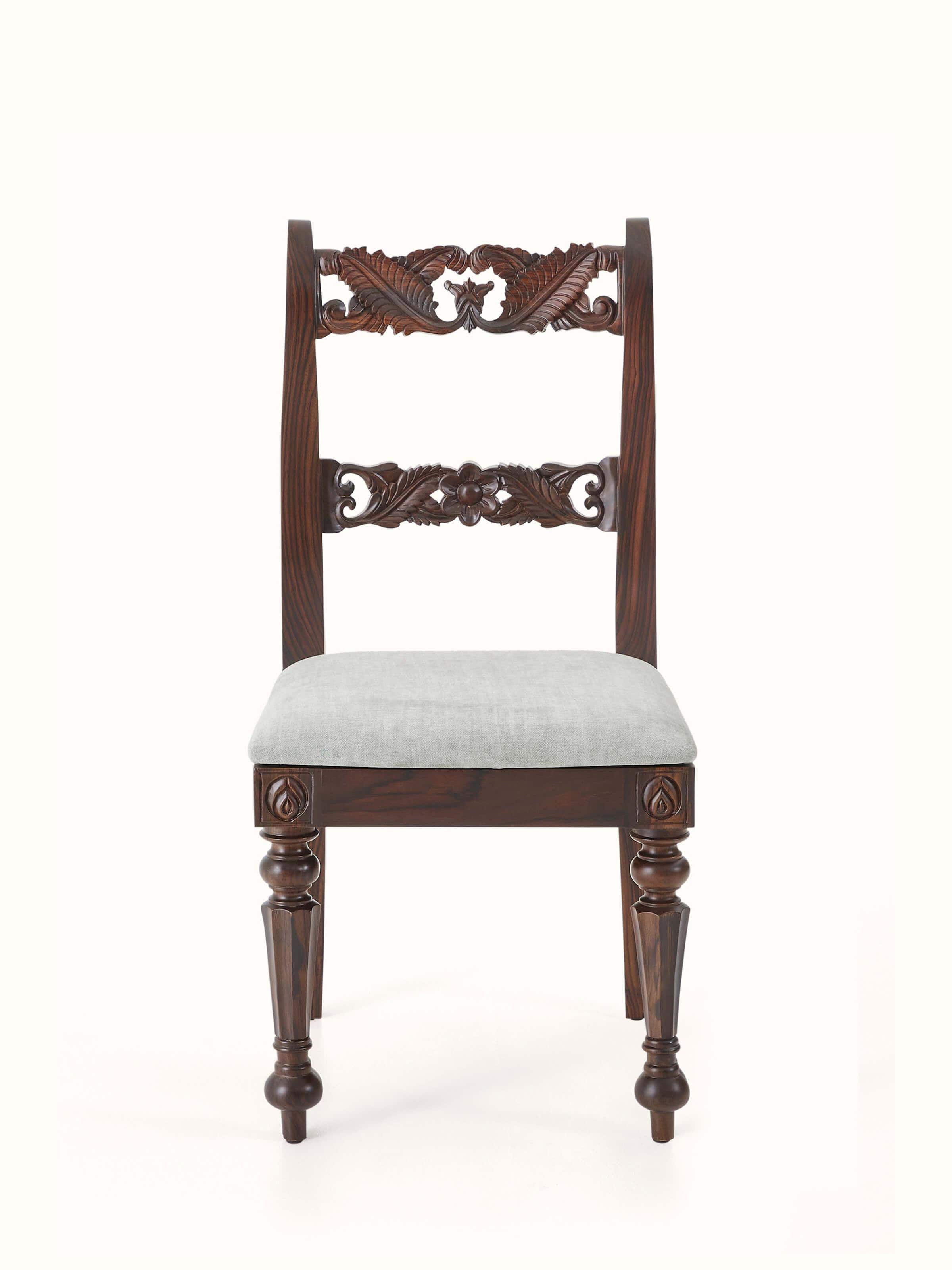 Front view of upholstered carved rosewood dining chair, showcasing intricate carvings and plush seating.