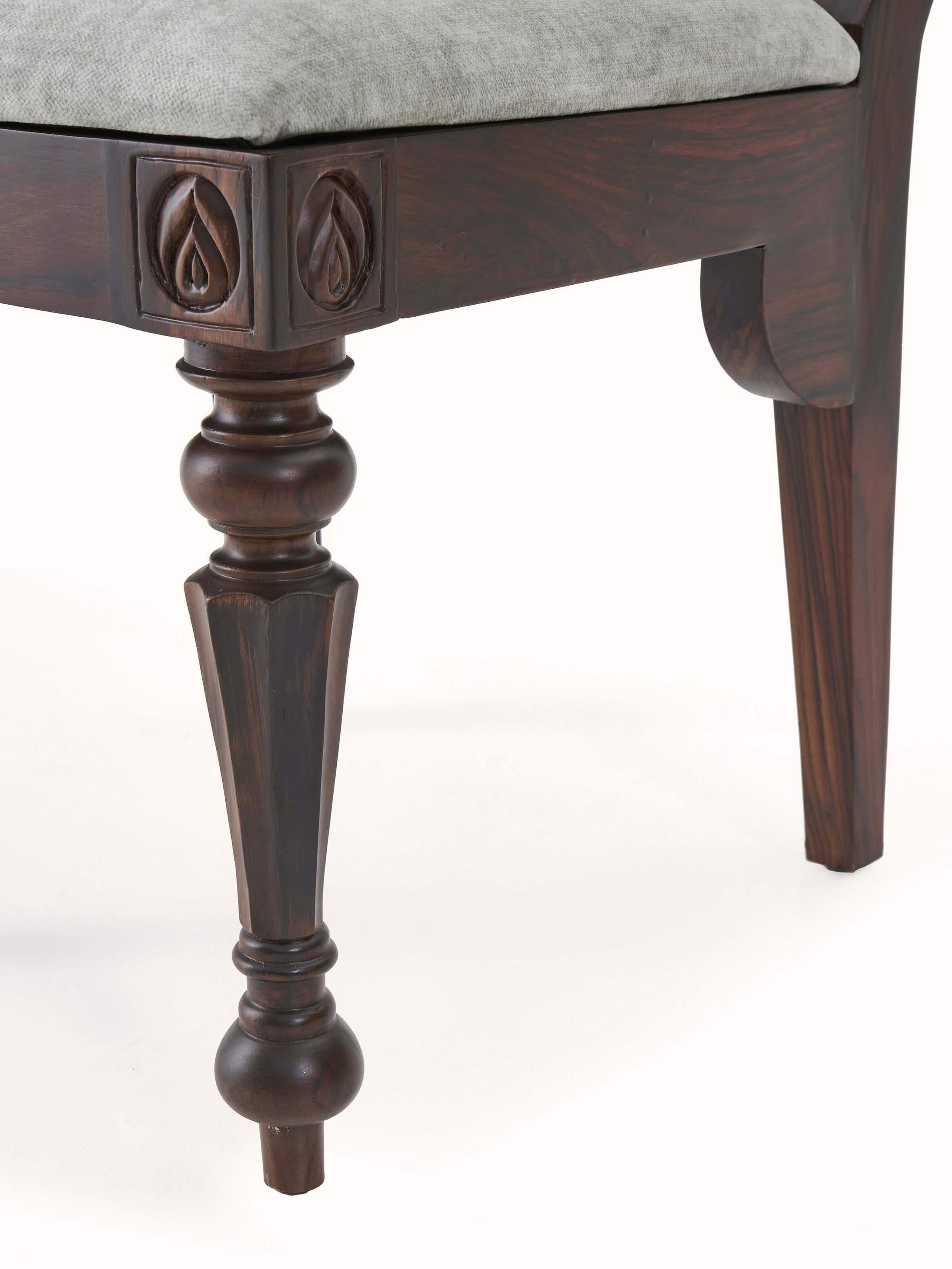 Angled view of upholstered carved rosewood dining chair, emphasizing the elegant design and craftsmanship.