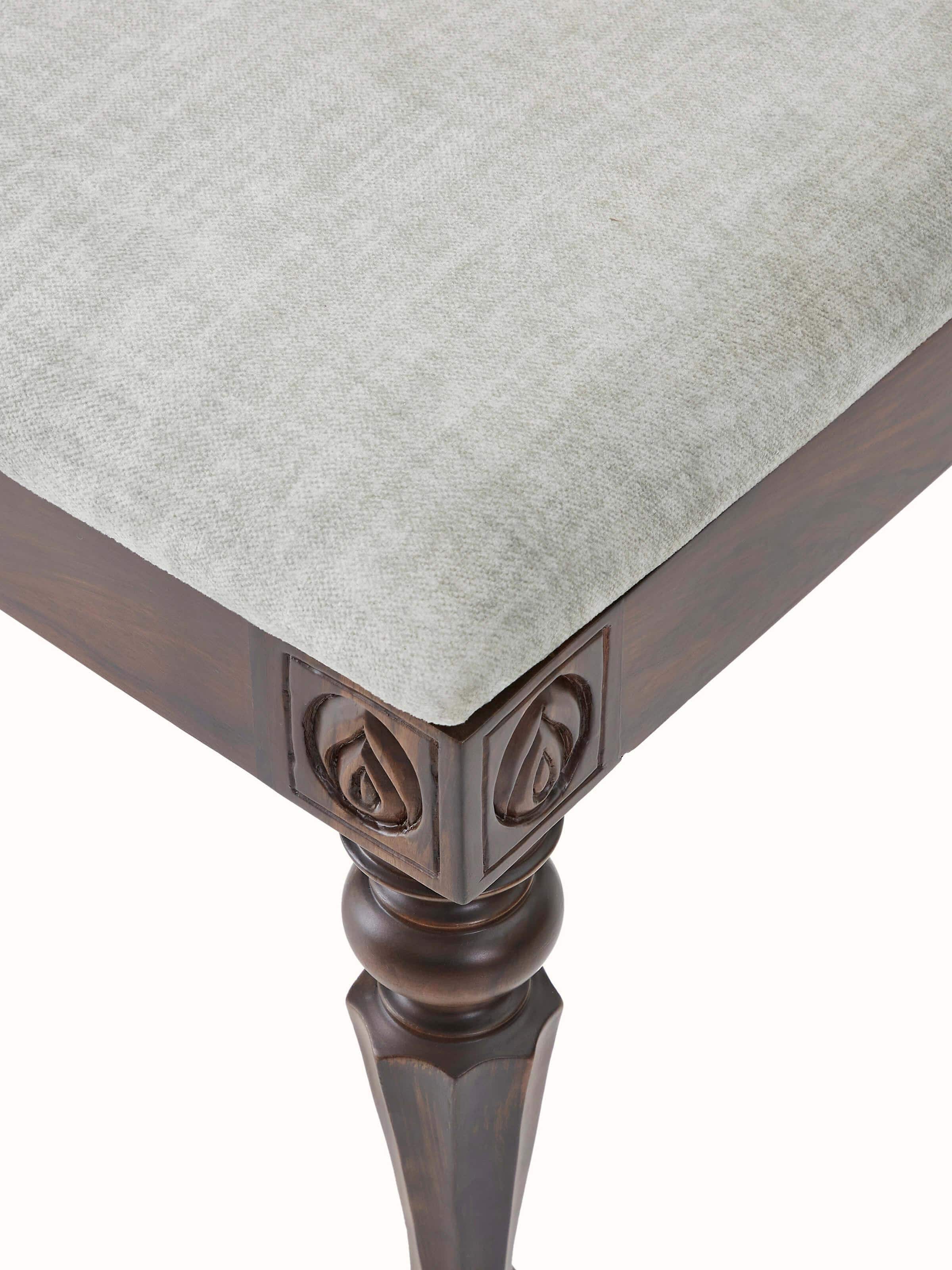 Detailed view of carved rosewood dining chair’s backrest, showcasing intricate carving patterns and upholstered detail.