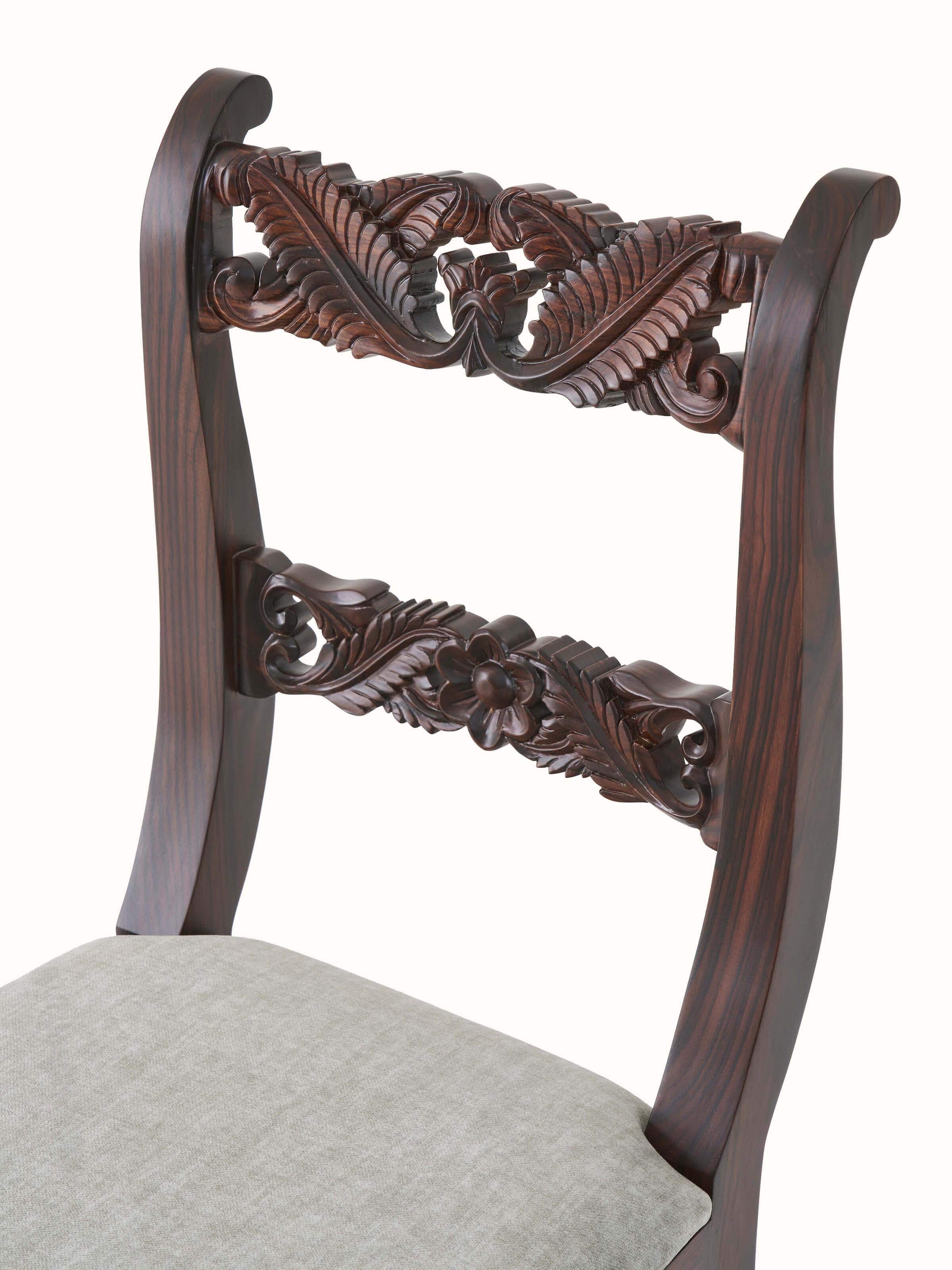 Close-up of carved rosewood dining chair's legs and base, highlighting the rich wood grain and craftsmanship.