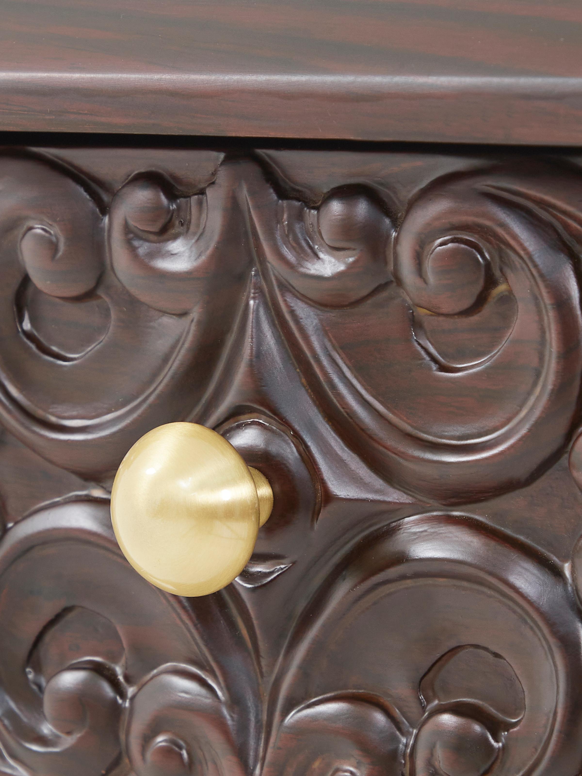 Angled view of the rosewood bedside table, emphasizing the depth and texture of the carvings.