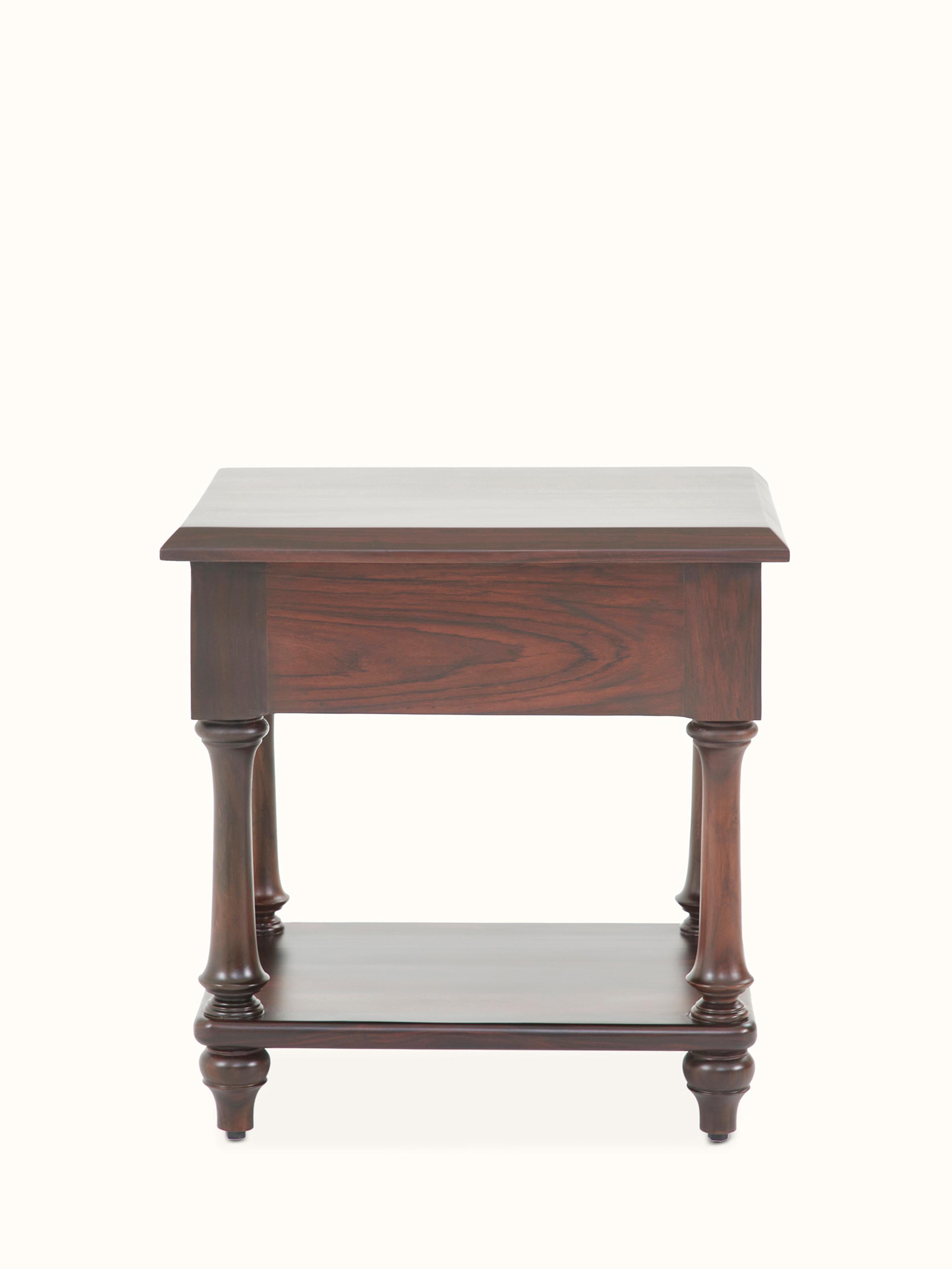 Side view with focus on the carved patterns and overall design of the rosewood bedside table.