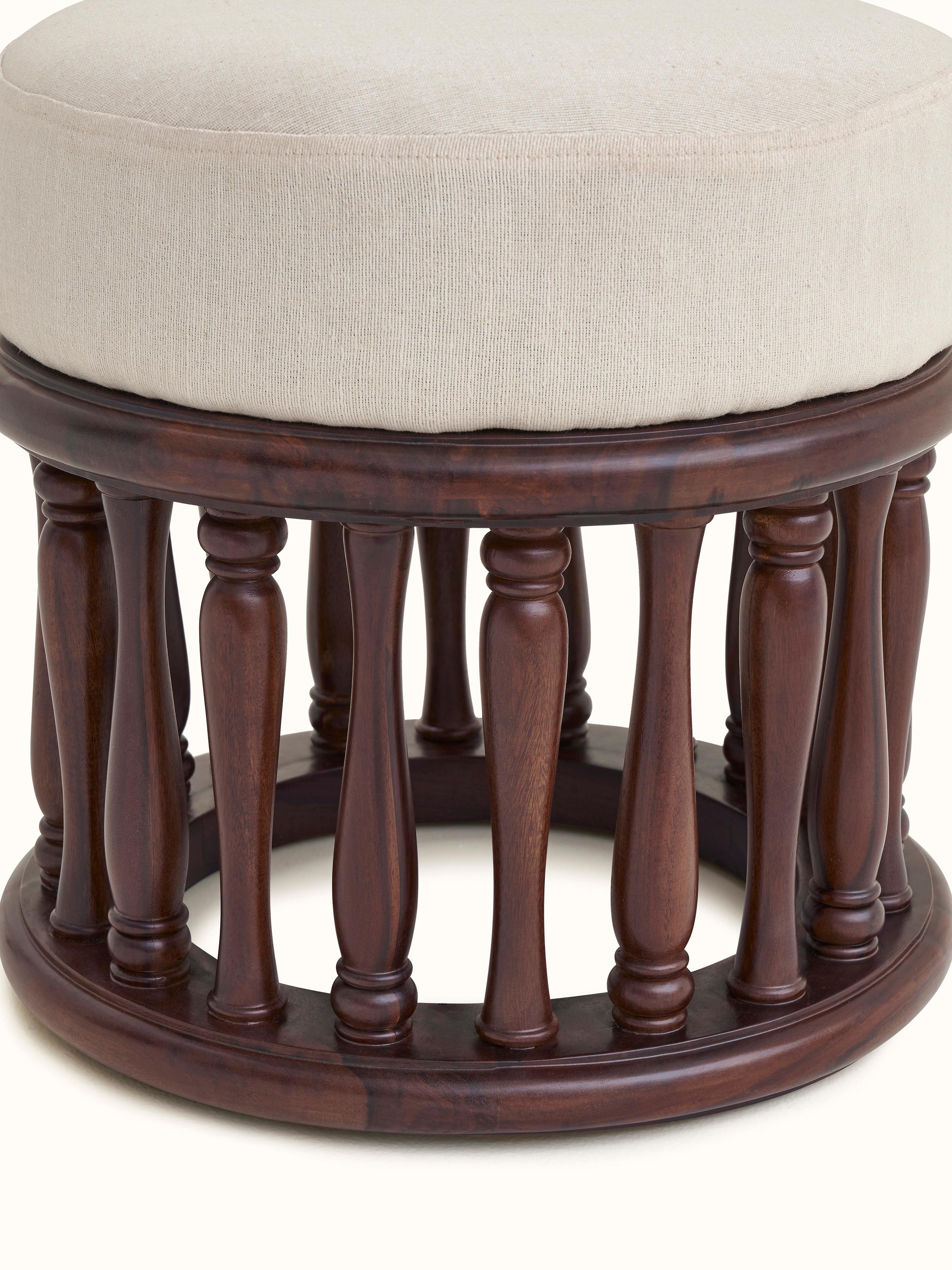 Detailed view of upholstered Sheesham wood round pouffe, emphasizing the plush top and the elegant wood detailing