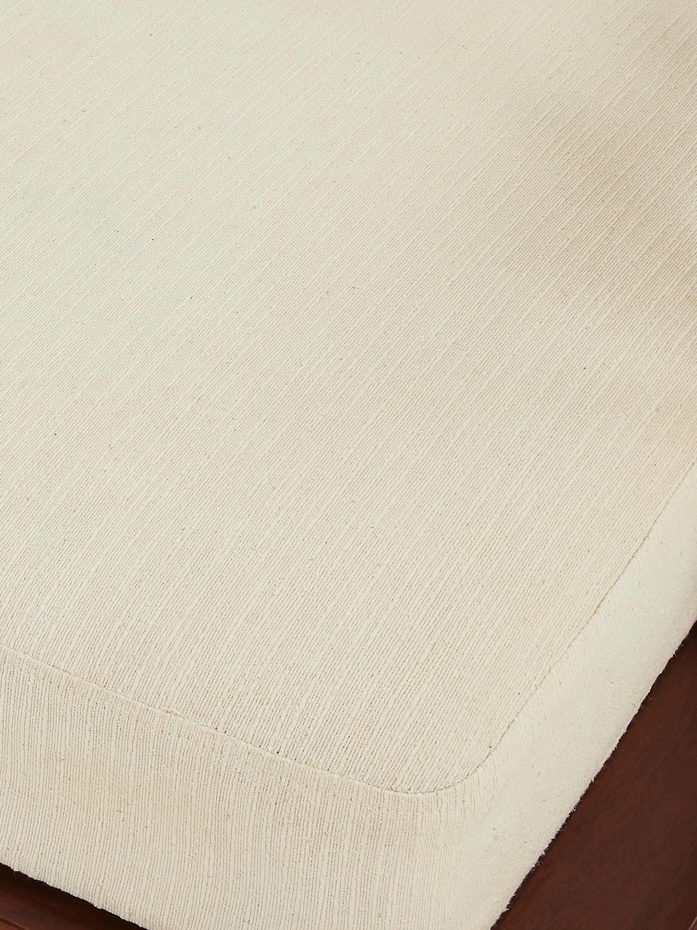 Close-up of Teak finish upholstered Sheesham wood daybed’s upholstered section, emphasizing the quality of the fabric and padding