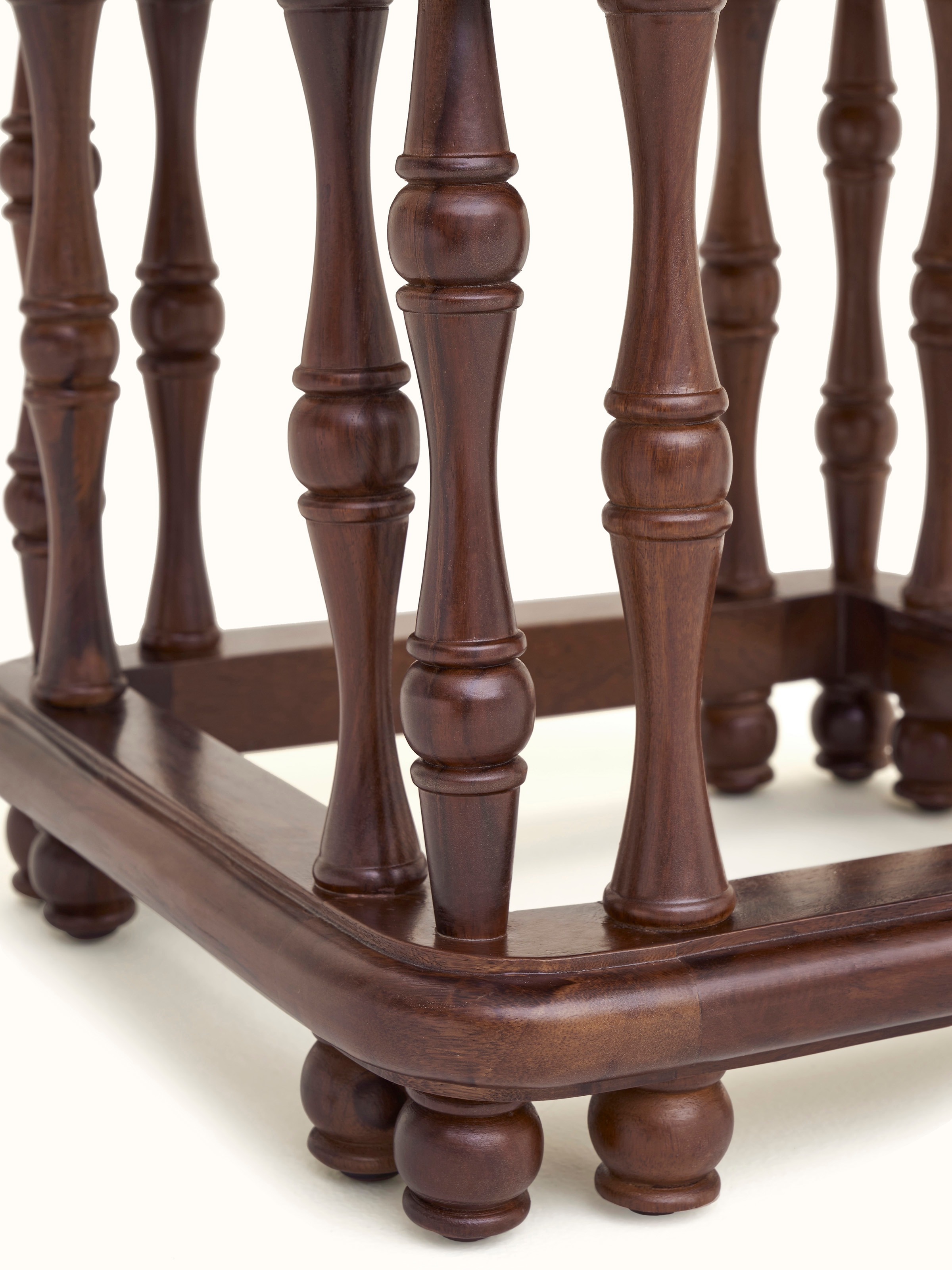 Detailed view of the Sheesham wood base of the ottoman, highlighting the craftsmanship and wood finish.