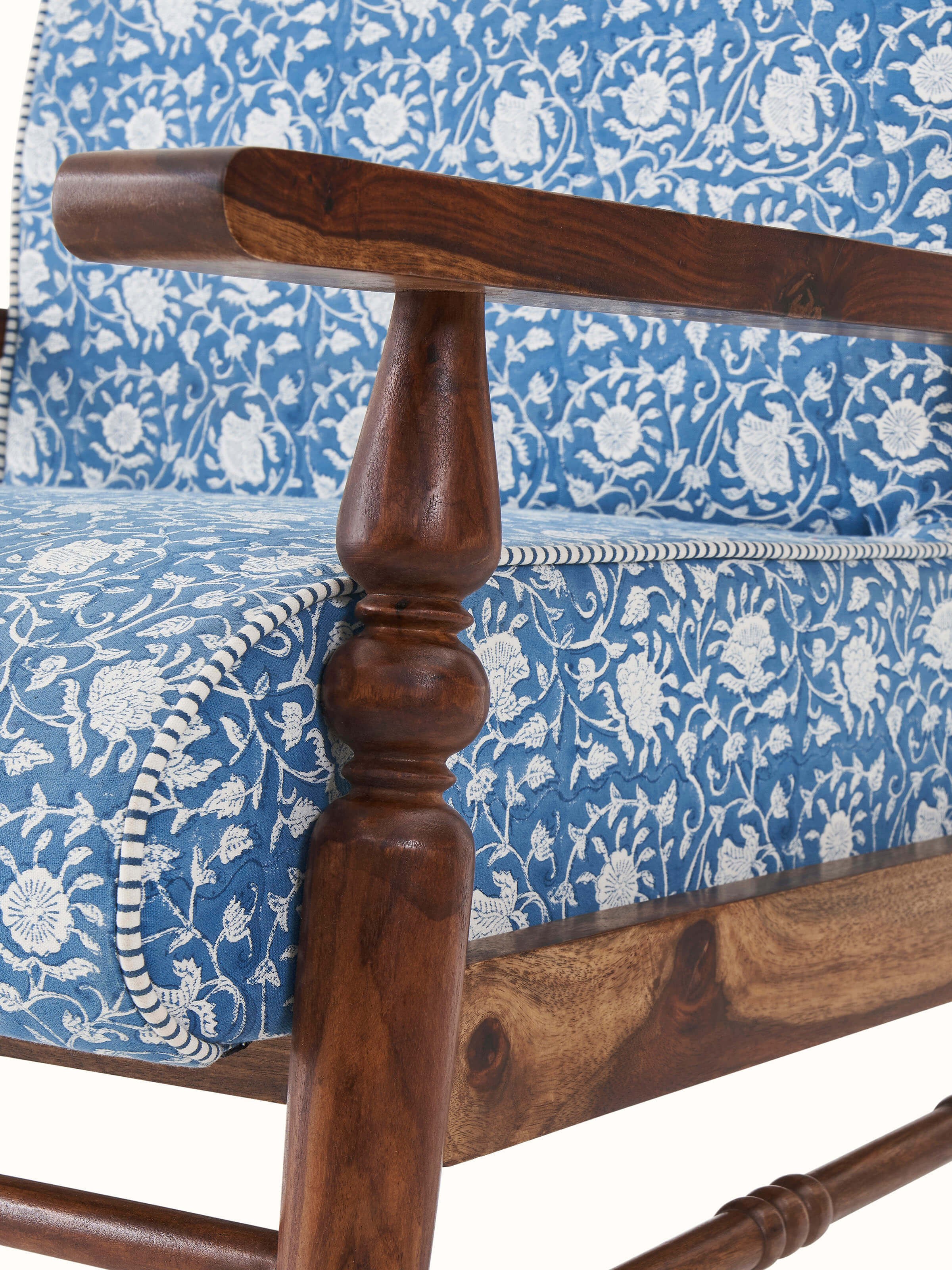Angled view of the Sheesham wood armchair with block print upholstery, highlighting the armrests and seat design.