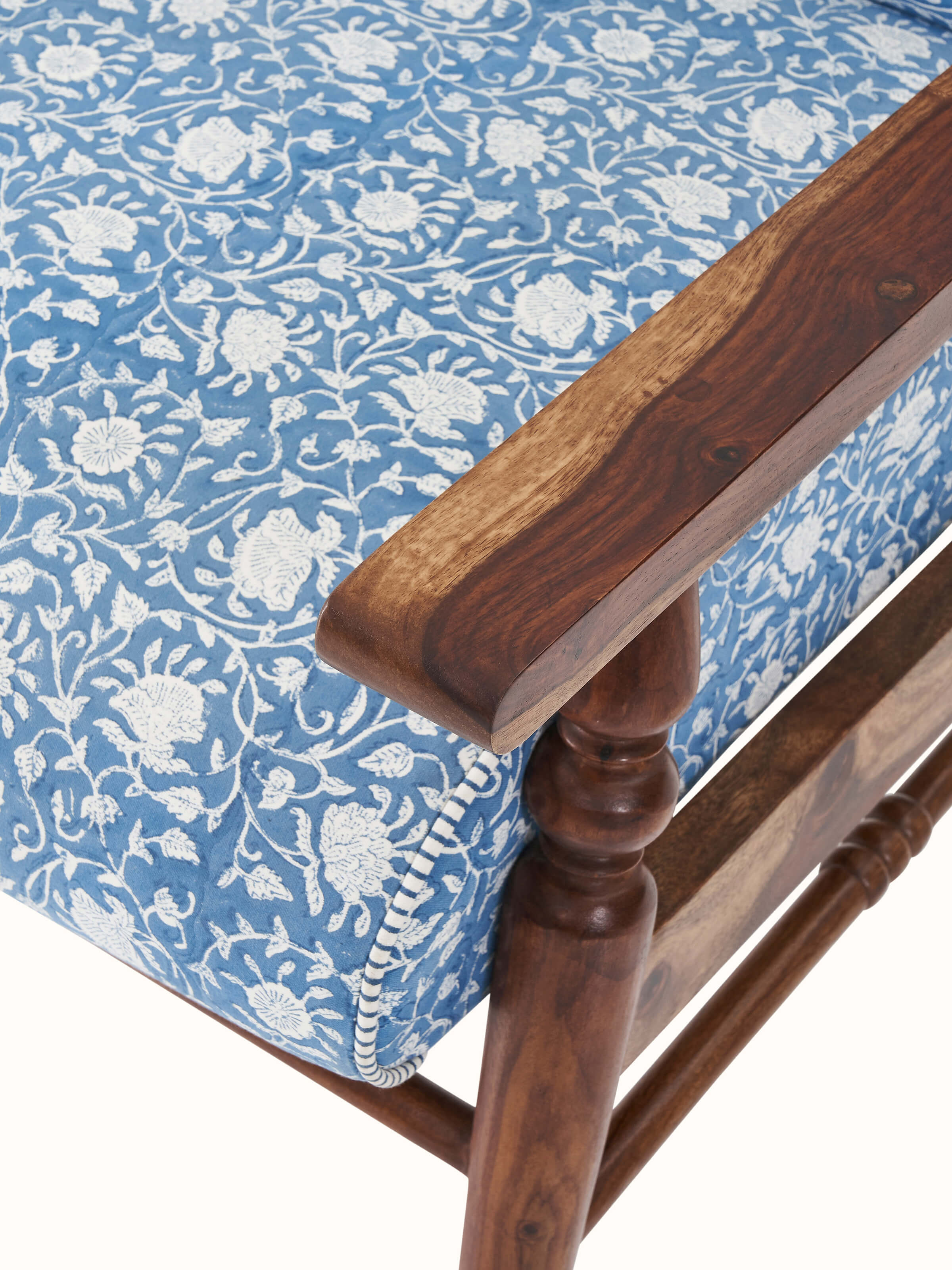 Detailed view of the Sheesham wood armchair's legs and base, showcasing its sturdy construction and elegant design.