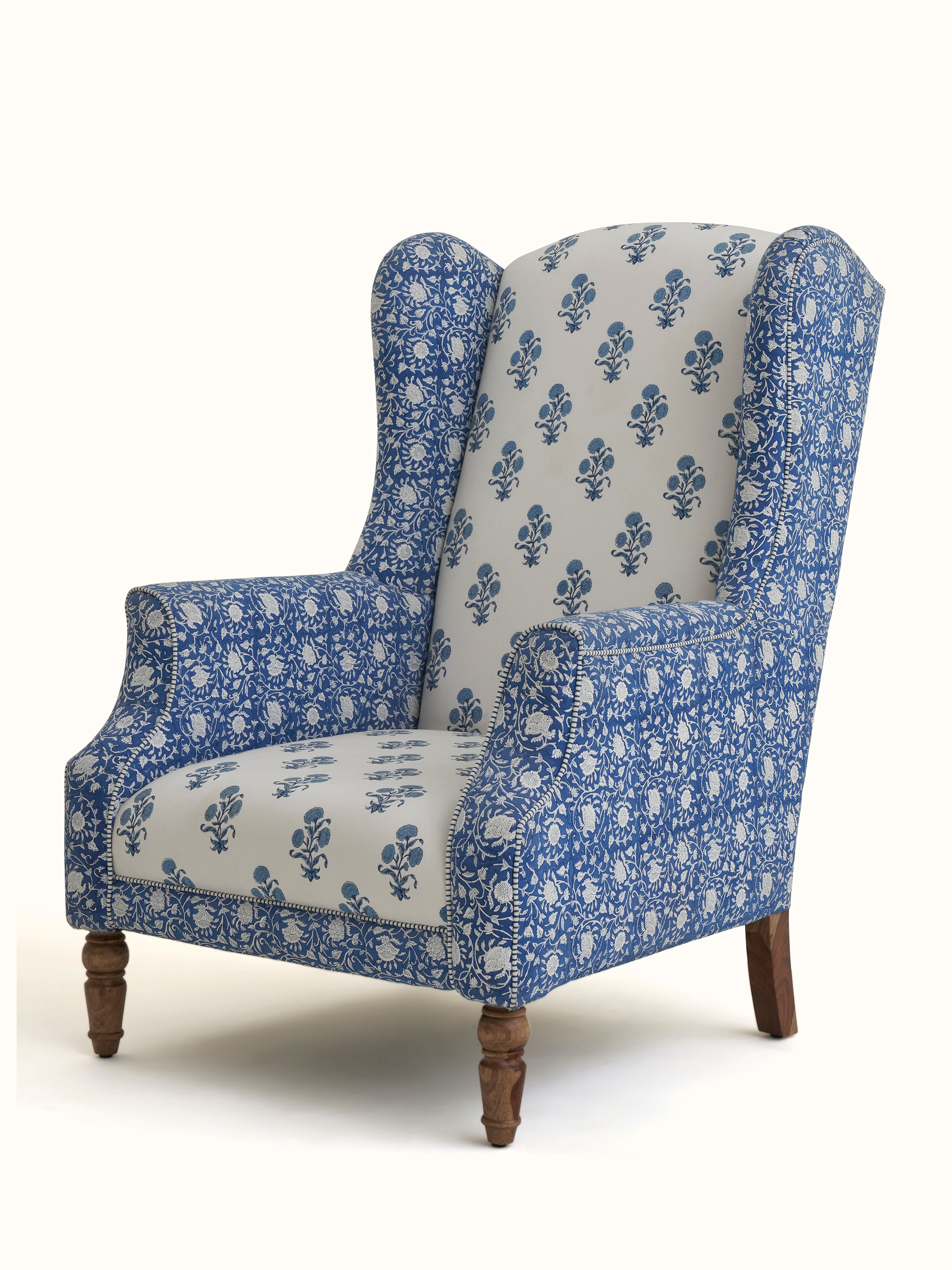 Close-up of the block print detailing on the upholstered Sheesham wood wing chair, emphasizing the craftsmanship and textile pattern