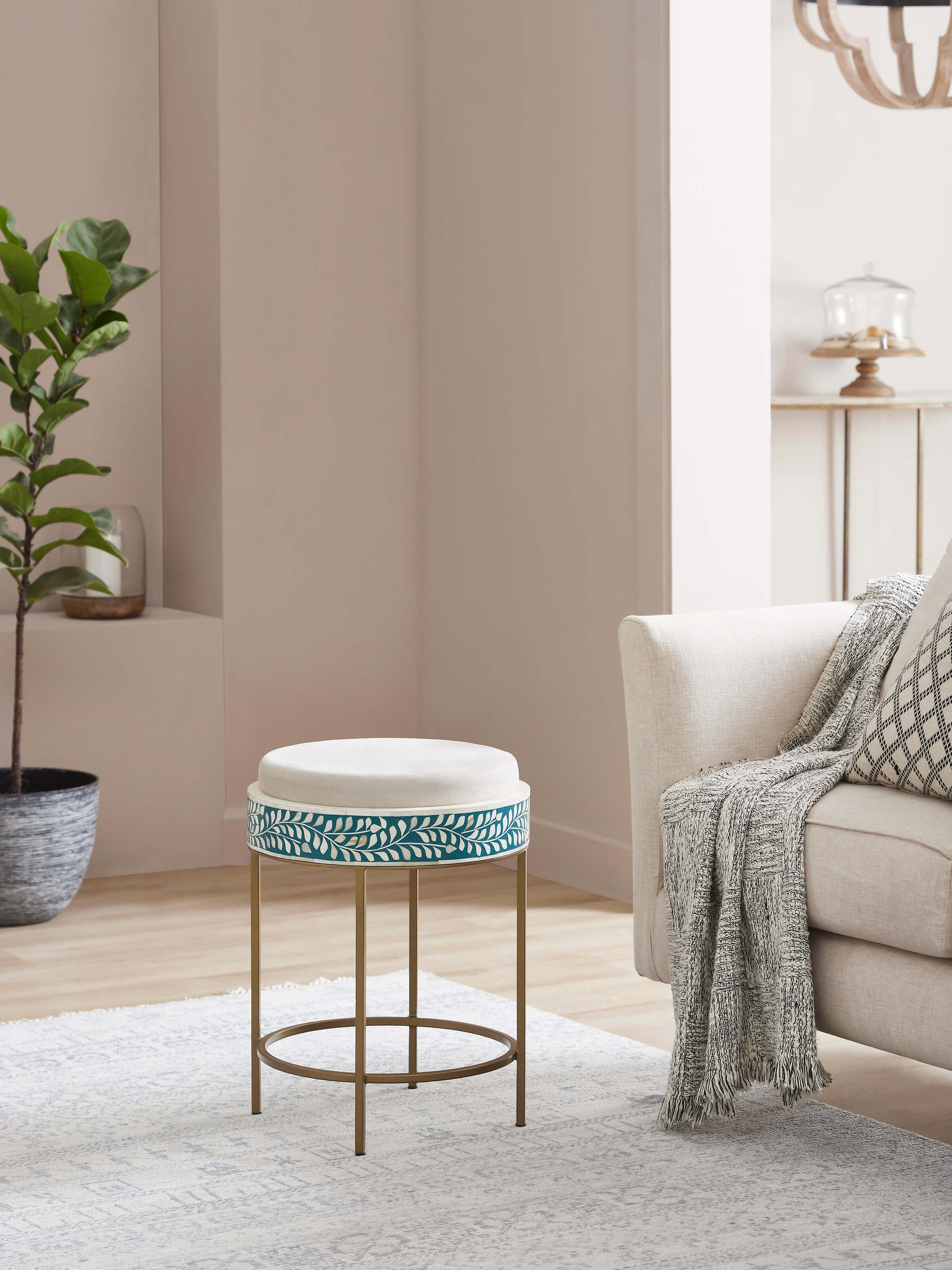 Side view of the upholstered metal stool with bone inlay, highlighting its elegant design and detailed workmanship.