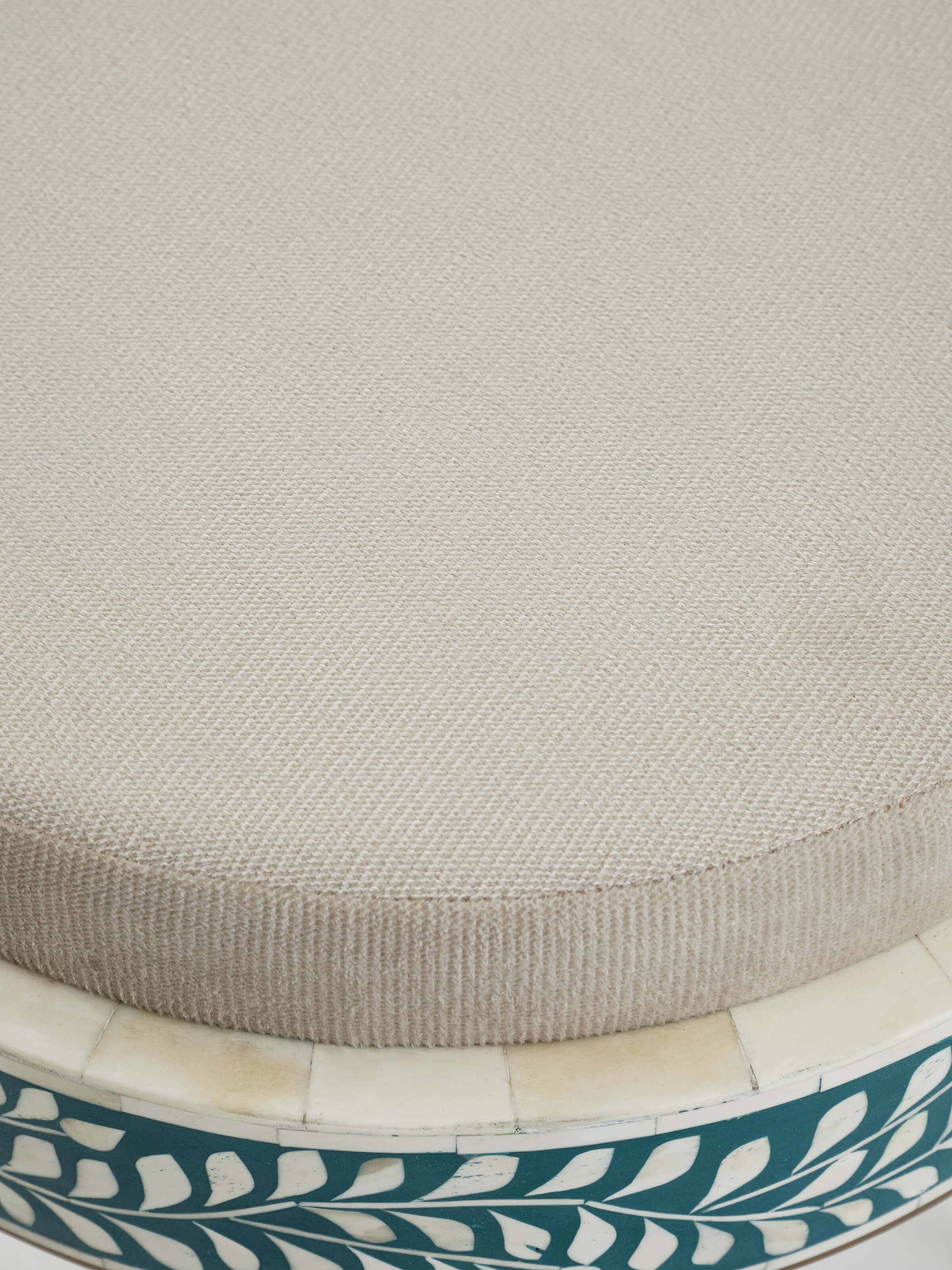 Detailed view of the metal frame and bone inlay on the upholstered stool, showcasing the fine craftsmanship and design.