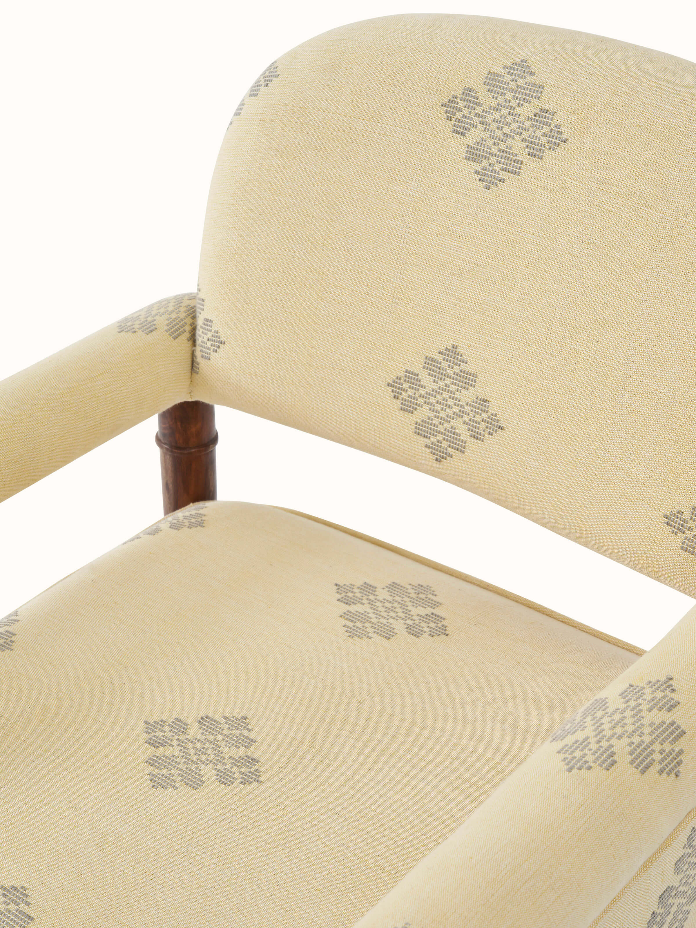 Detailed view of the armrest and back design of the upholstered sheesham wood armchair