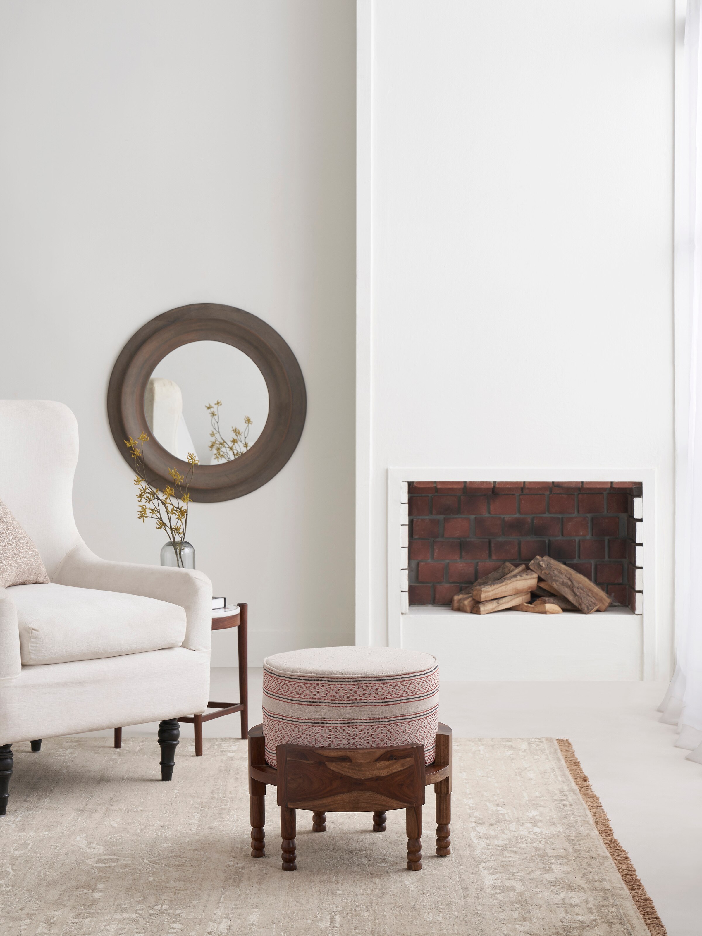 Side view of Bawan Buti upholstered Sheesham wood ottoman highlighting its shape and upholstery