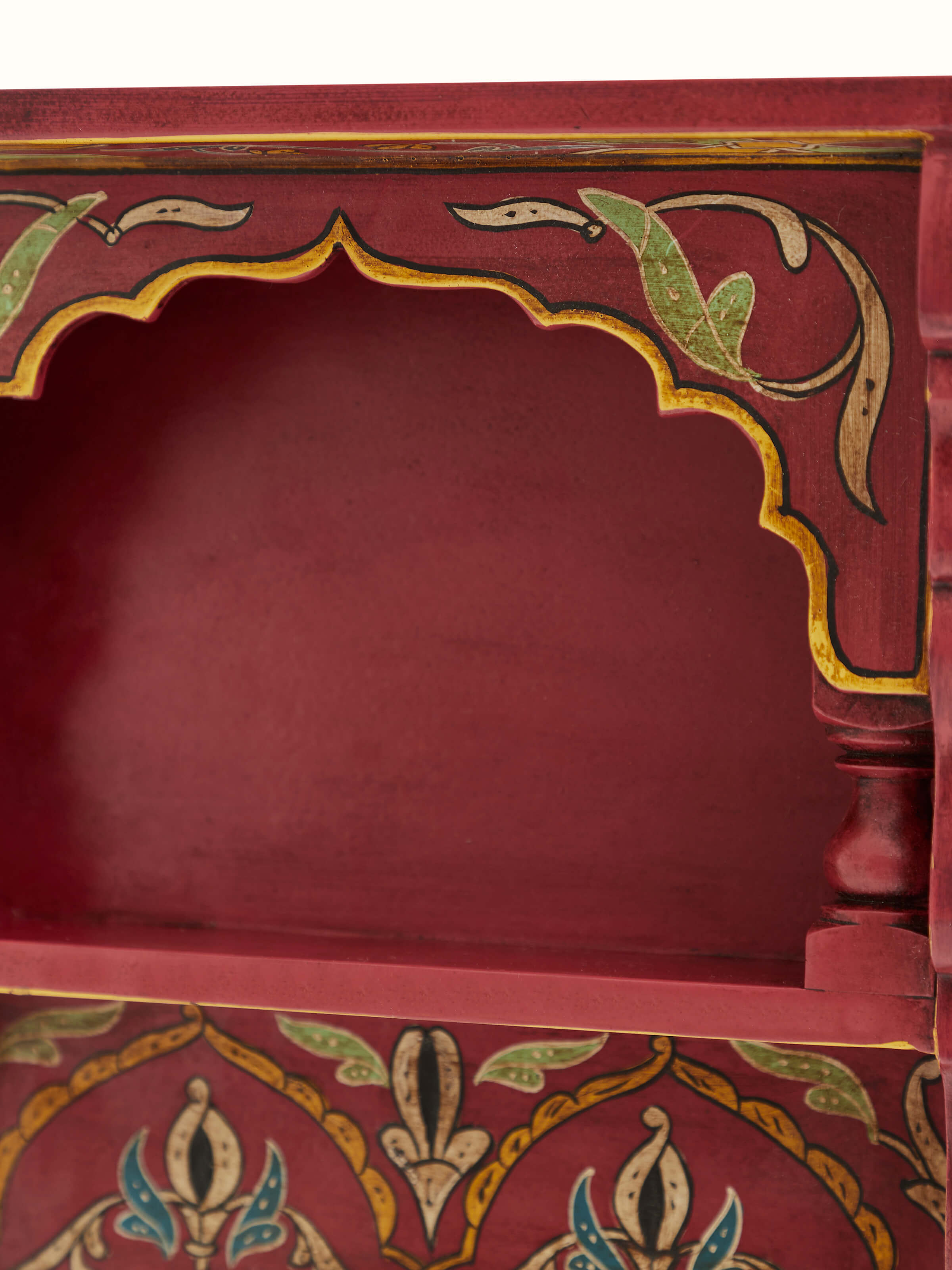 Close-up view of the painted details on the brown miniature wall shelf, focusing on the artwork and texture.