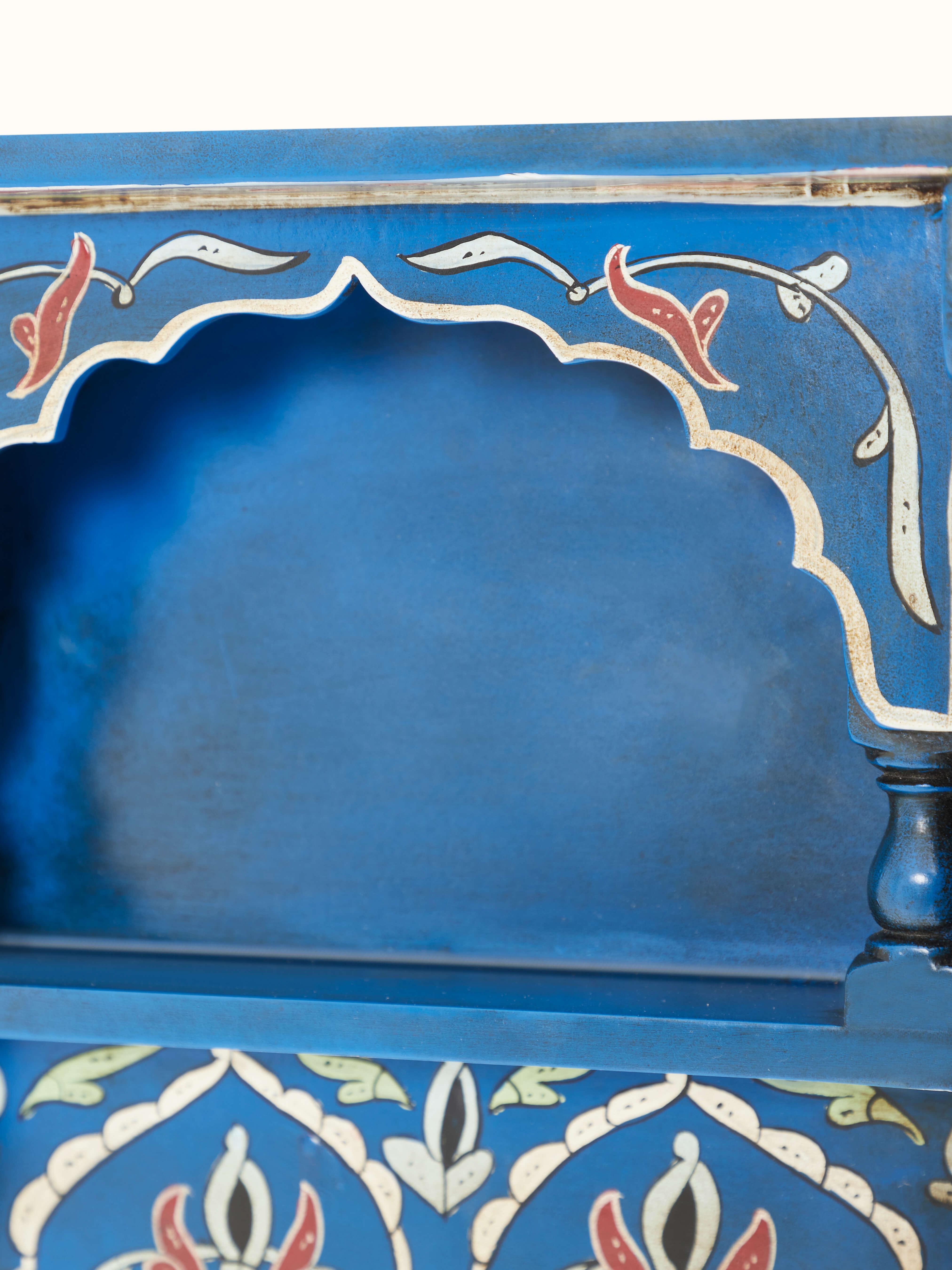 Close-up of blue miniature painted wall shelf focusing on the detailed hand-painted designs and craftsmanship
