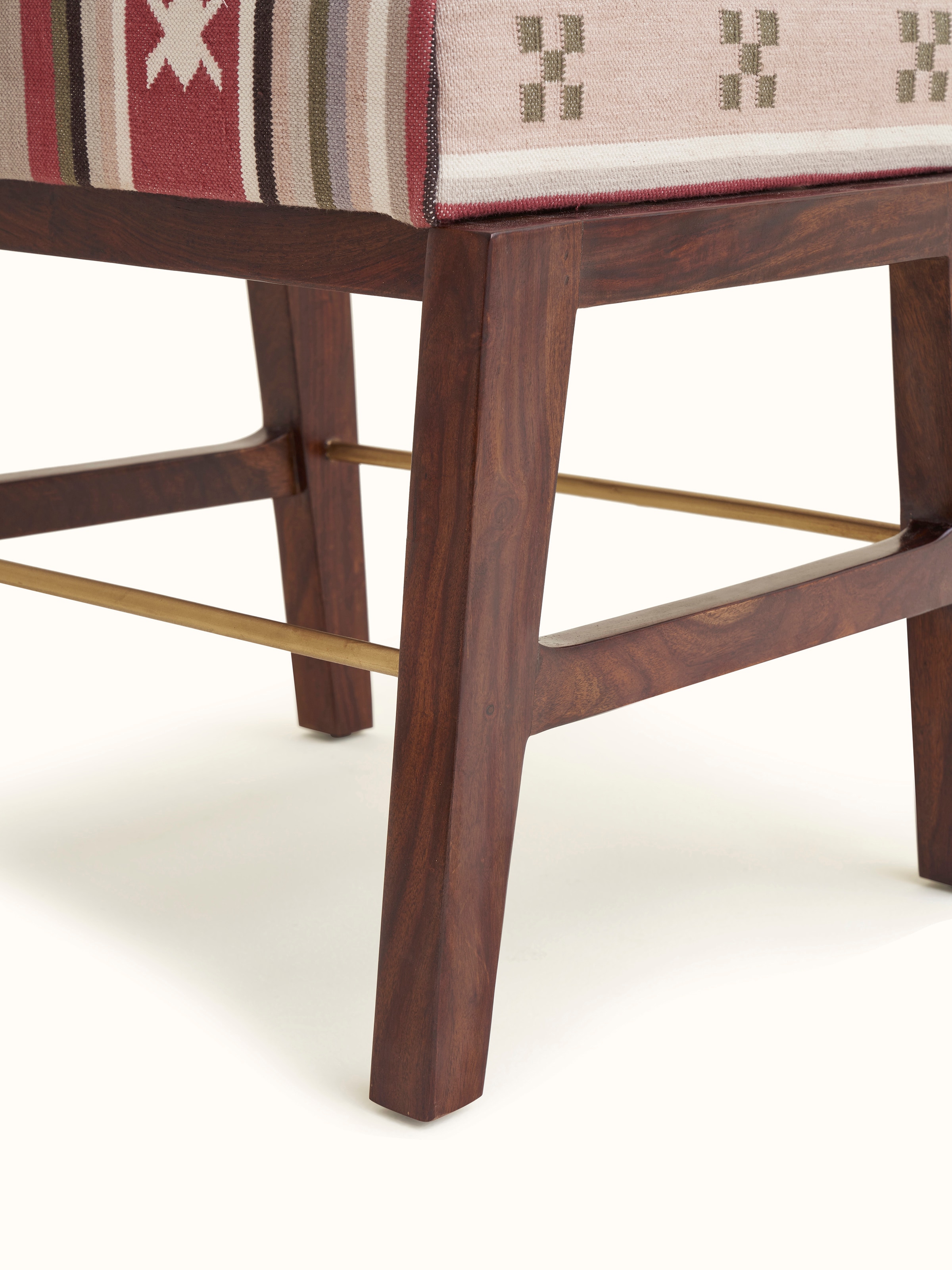 Close-up of the ottoman showing the Panja Dhurrie fabric upholstery and metal connector detail.