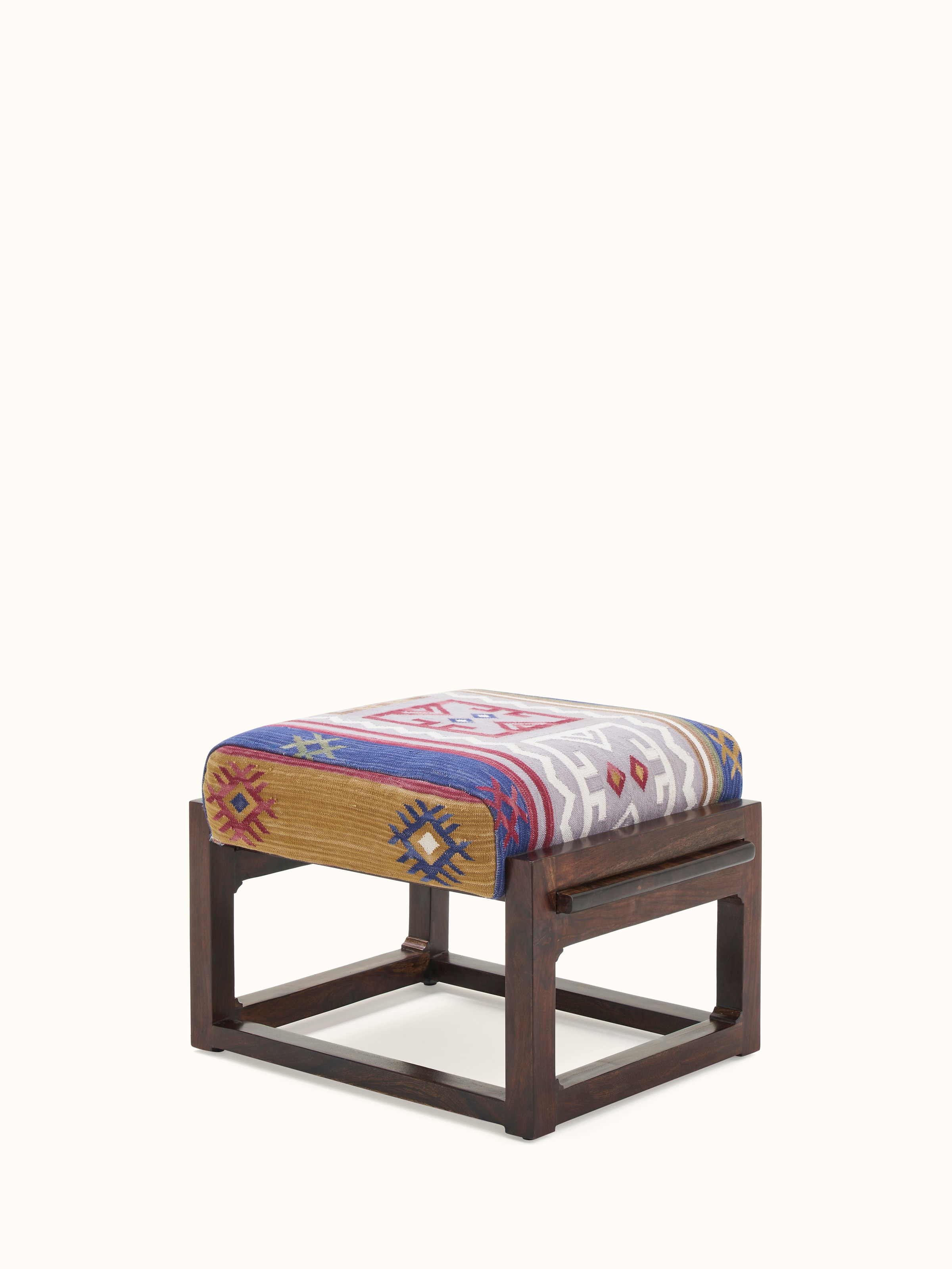 Side angle view of the Panja Dhurrie upholstered Sheesham wood ottoman, highlighting the fabric details and wooden base