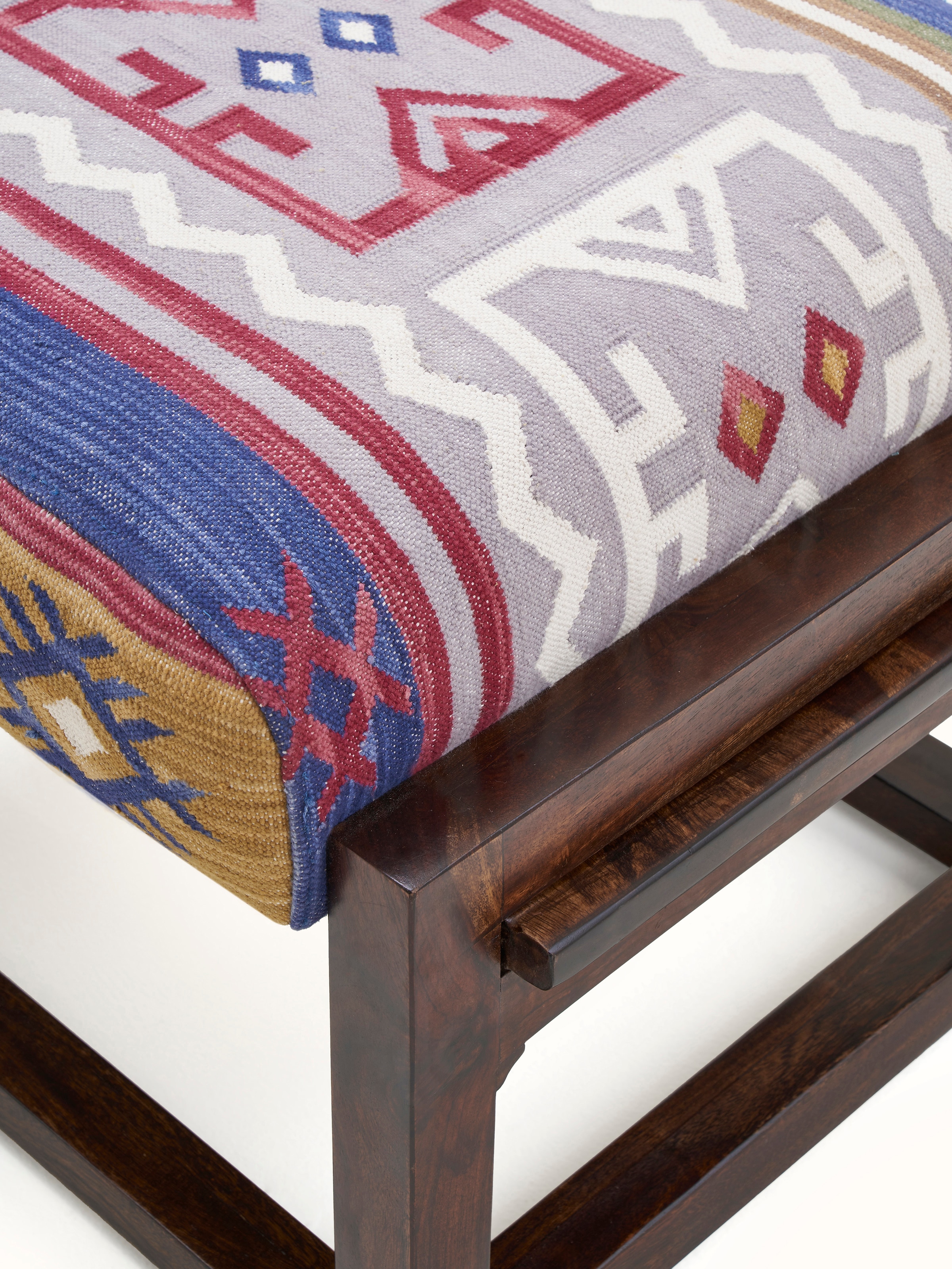 Detailed close-up of the Panja Dhurrie fabric upholstery on the Sheesham wood ottoman, focusing on the intricate patterns and texture