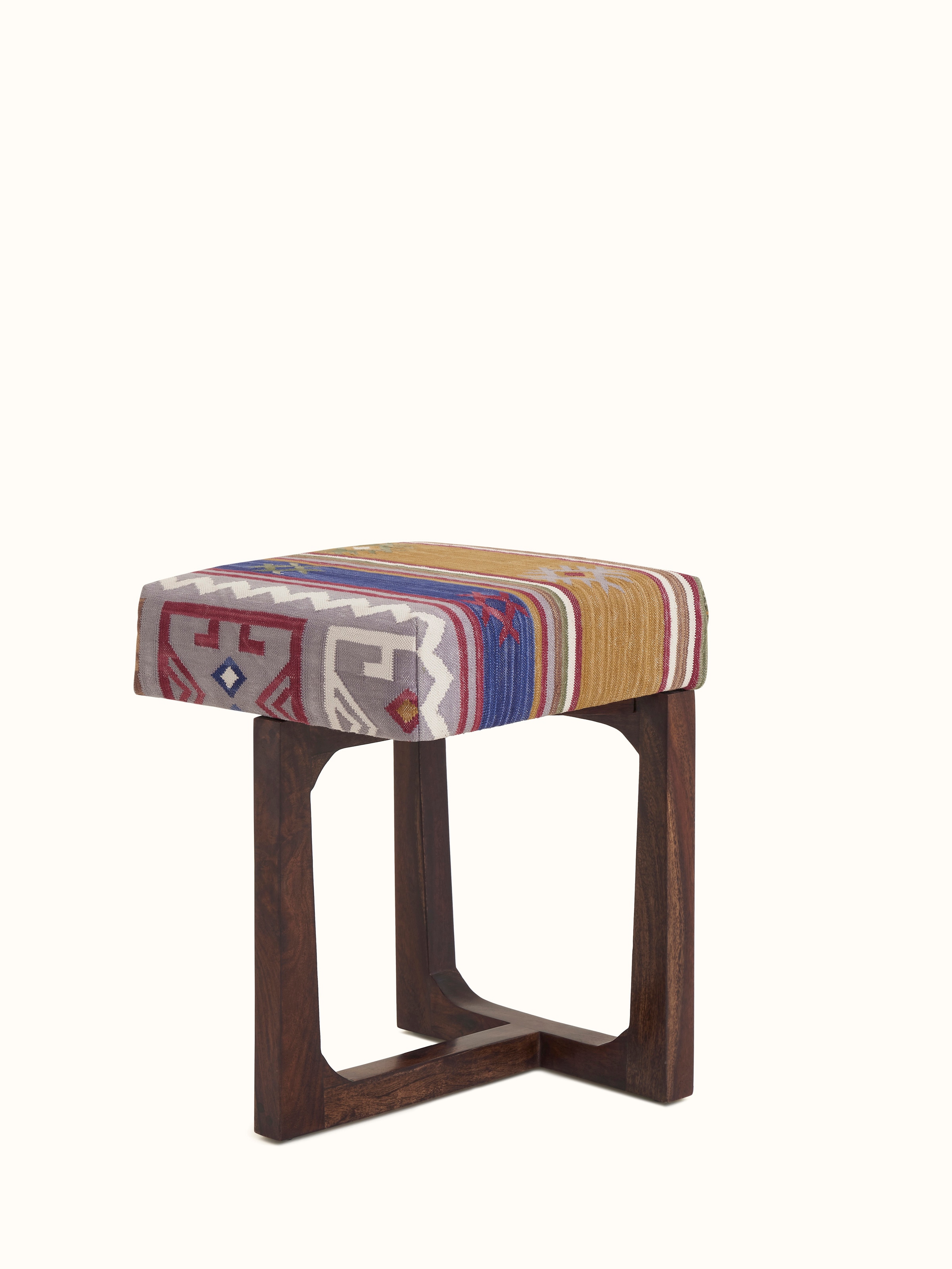Angled view of the Panja Dhurrie upholstered stool, highlighting the intricate fabric pattern and Sheesham wood details