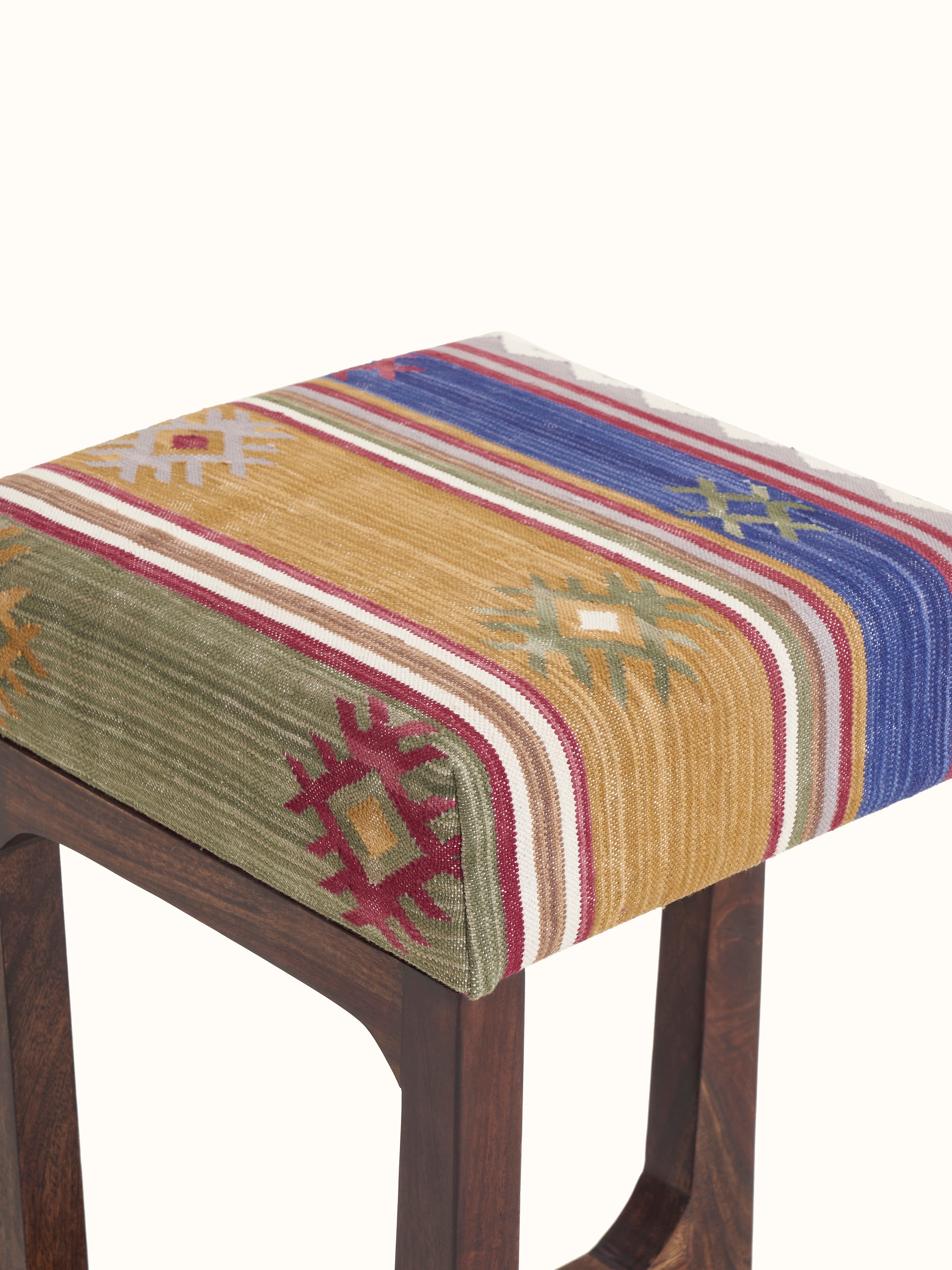 Close-up of the Panja Dhurrie fabric on the Sheesham wood stool, focusing on the texture and design of the upholstery