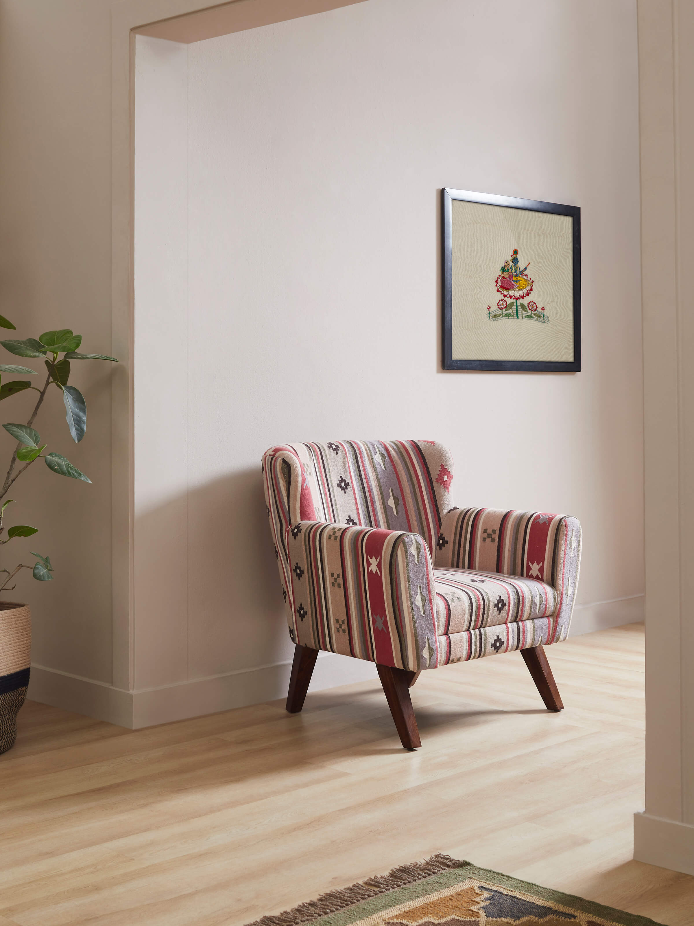 Side view of Panja Dhurrie upholstered Sheesham wood wing chair, highlighting the elegant winged back and rich wood finish