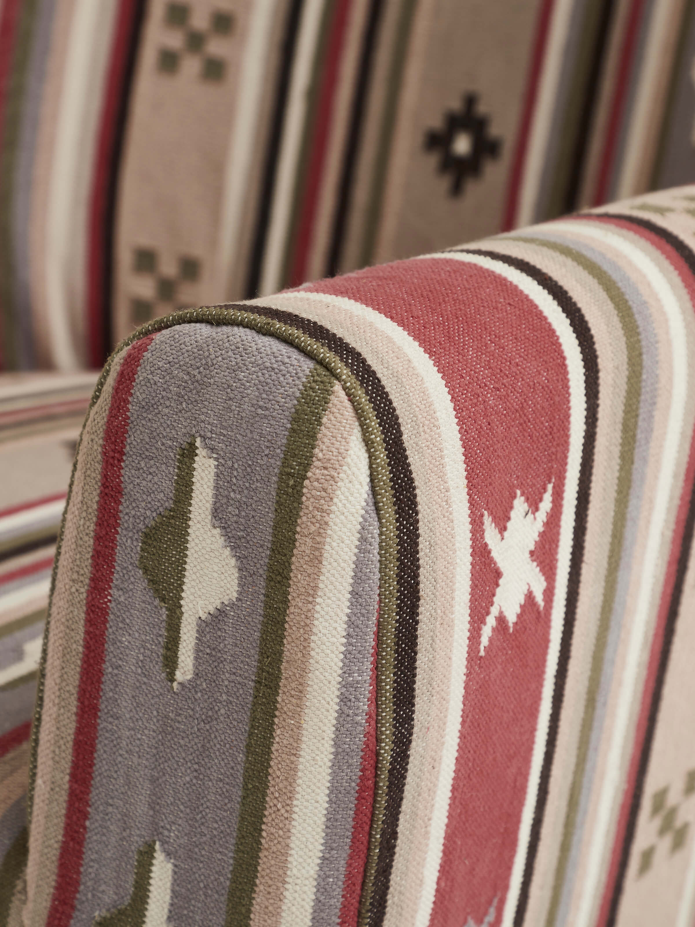 Angle view of Panja Dhurrie upholstered Sheesham wood wing chair, capturing the elegant design and upholstery