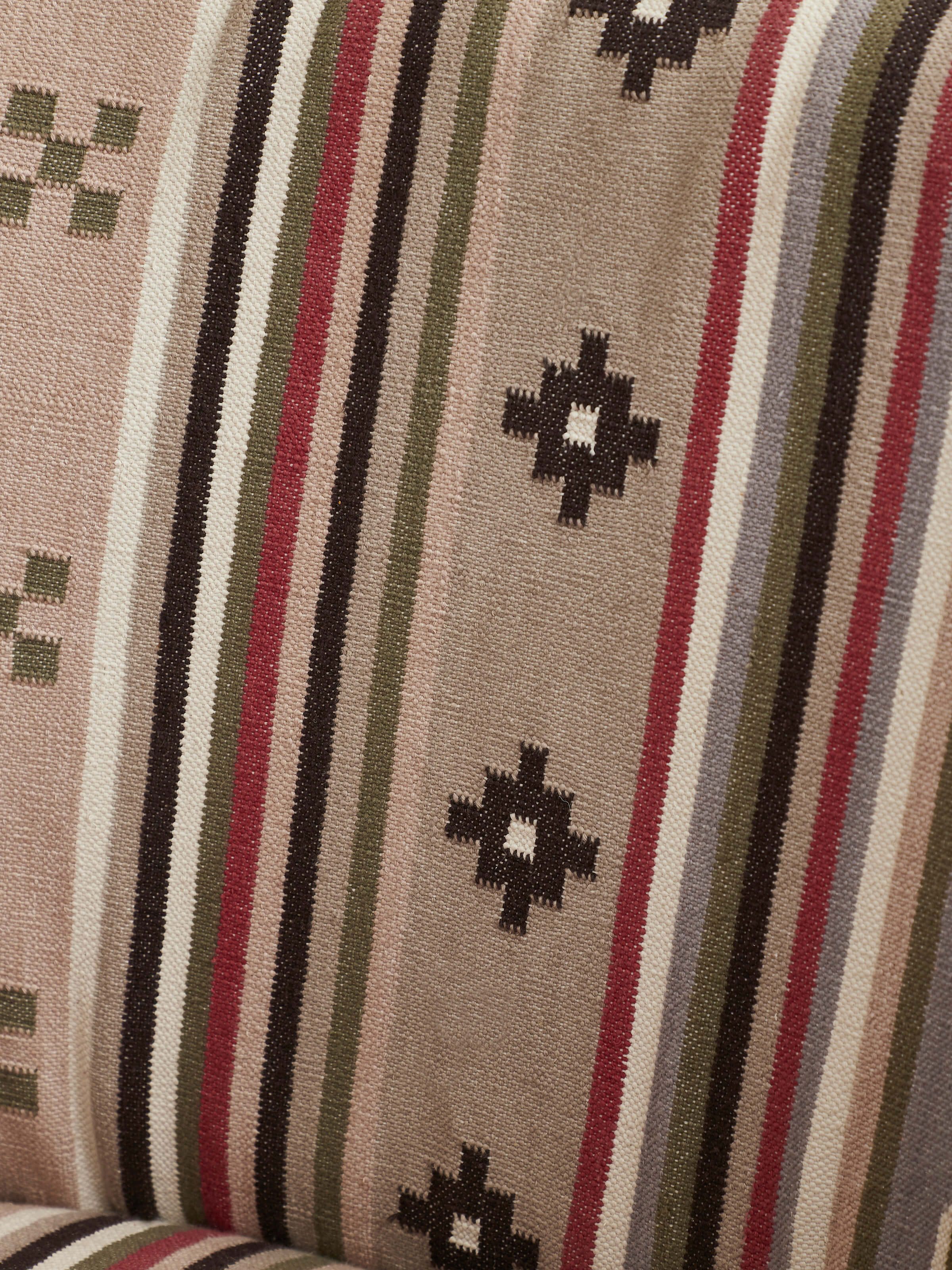 Close-up of the armrest and upholstery of Panja Dhurrie upholstered Sheesham wood wing chair, emphasizing the detailed stitching