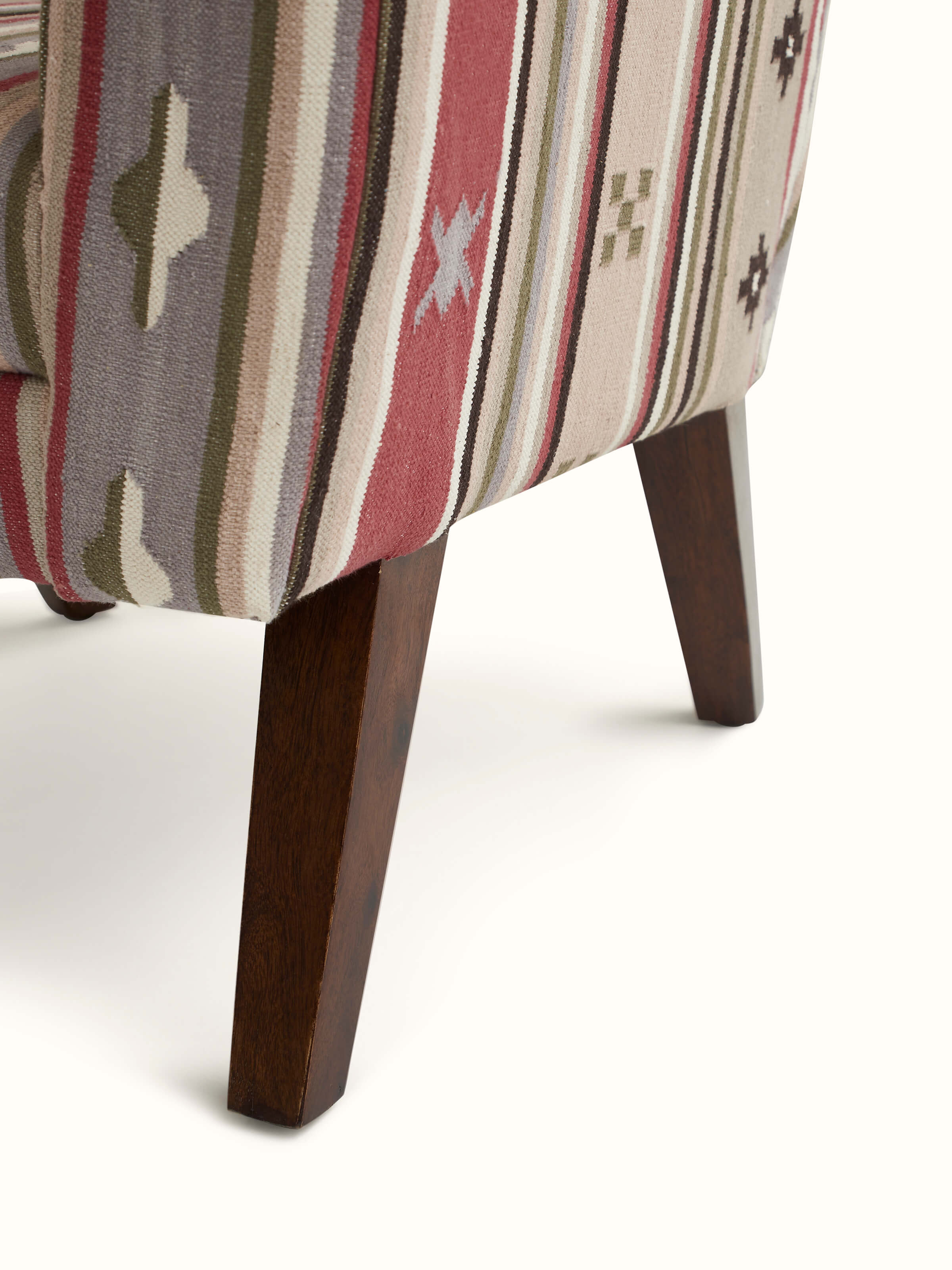 Overall view of the Panja Dhurrie upholstered Sheesham wood wing chair in a room setting, showing its style and functionality