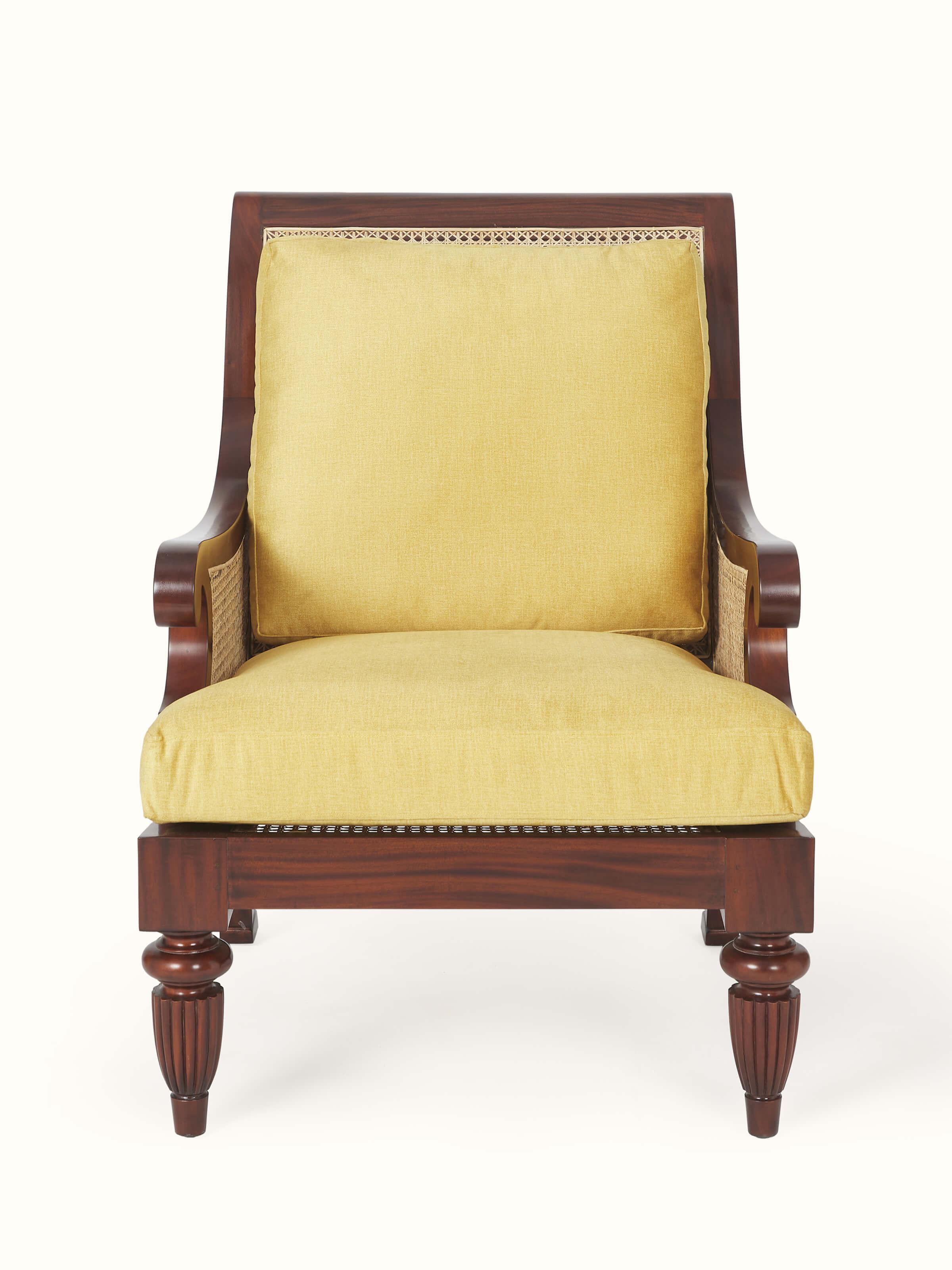 Front view of upholstered mahogany wood & cane armchair, showcasing detailed craftsmanship