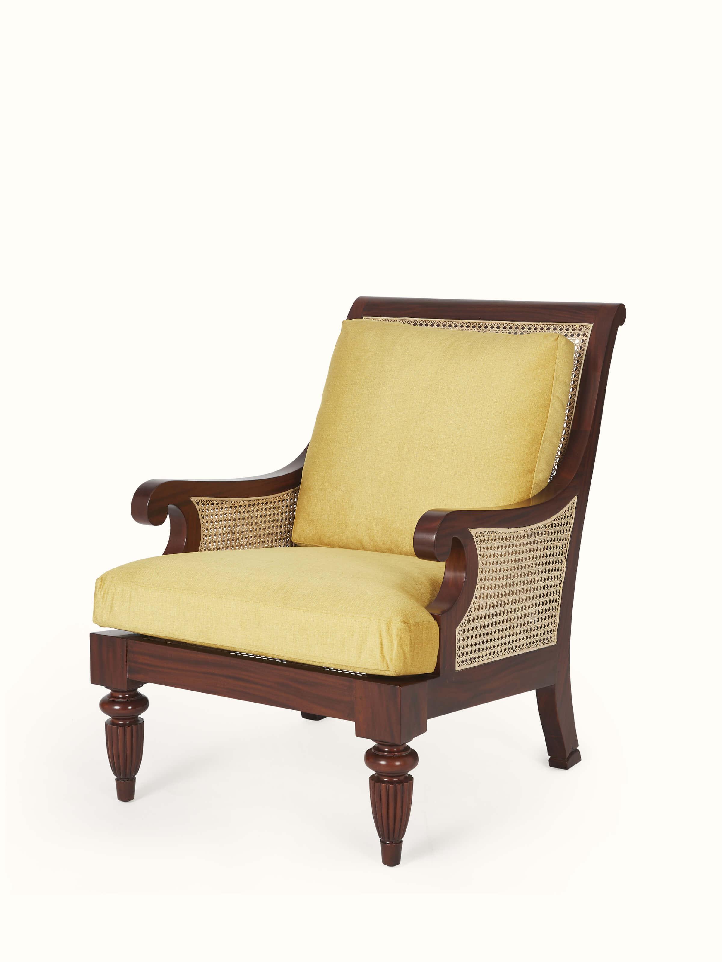 Side view of upholstered mahogany wood & cane armchair, highlighting the elegant design and upholstery