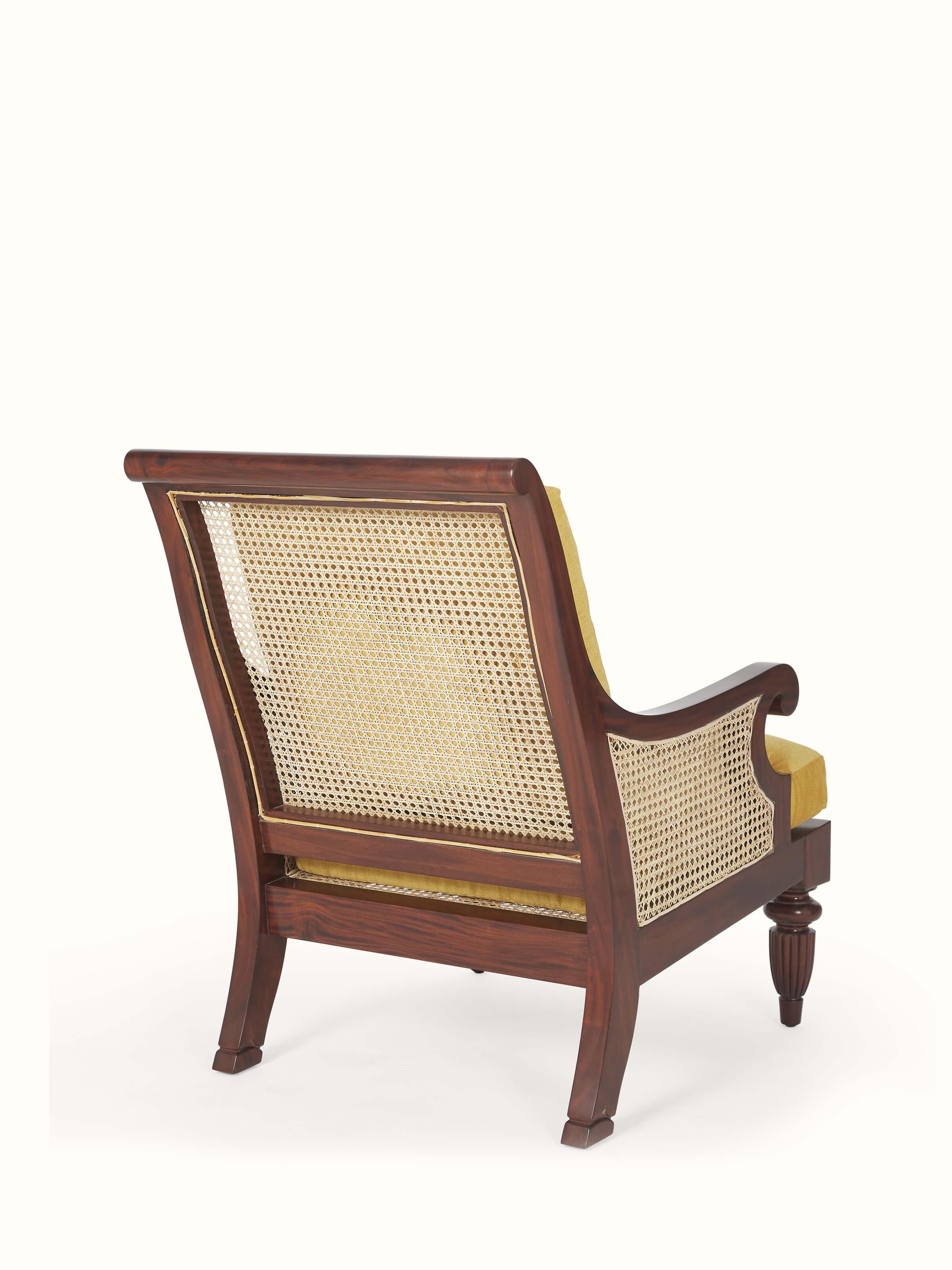 Overhead view of upholstered mahogany wood & cane armchair, emphasizing the blend of materials and design